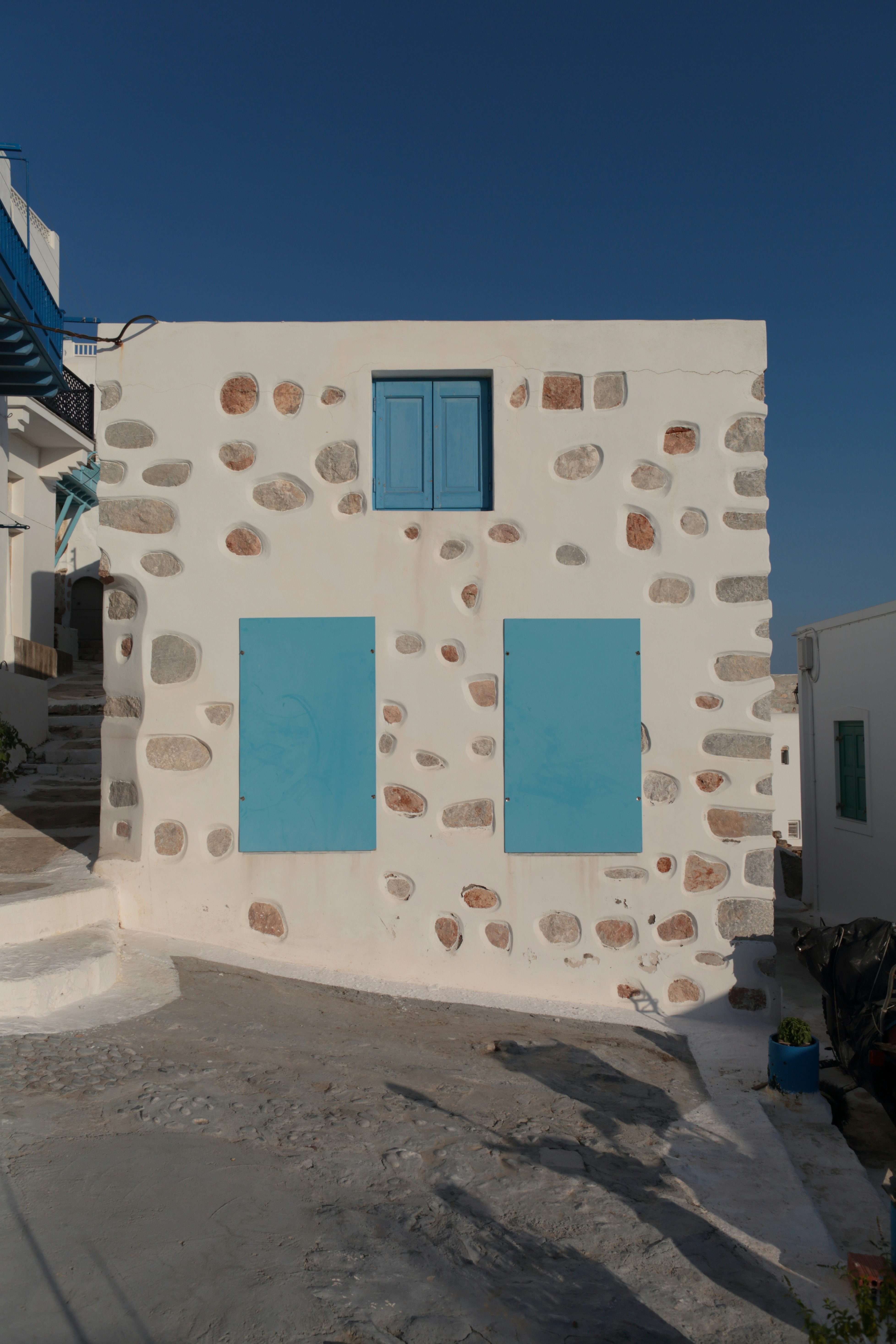 A white building with a blue door and windows