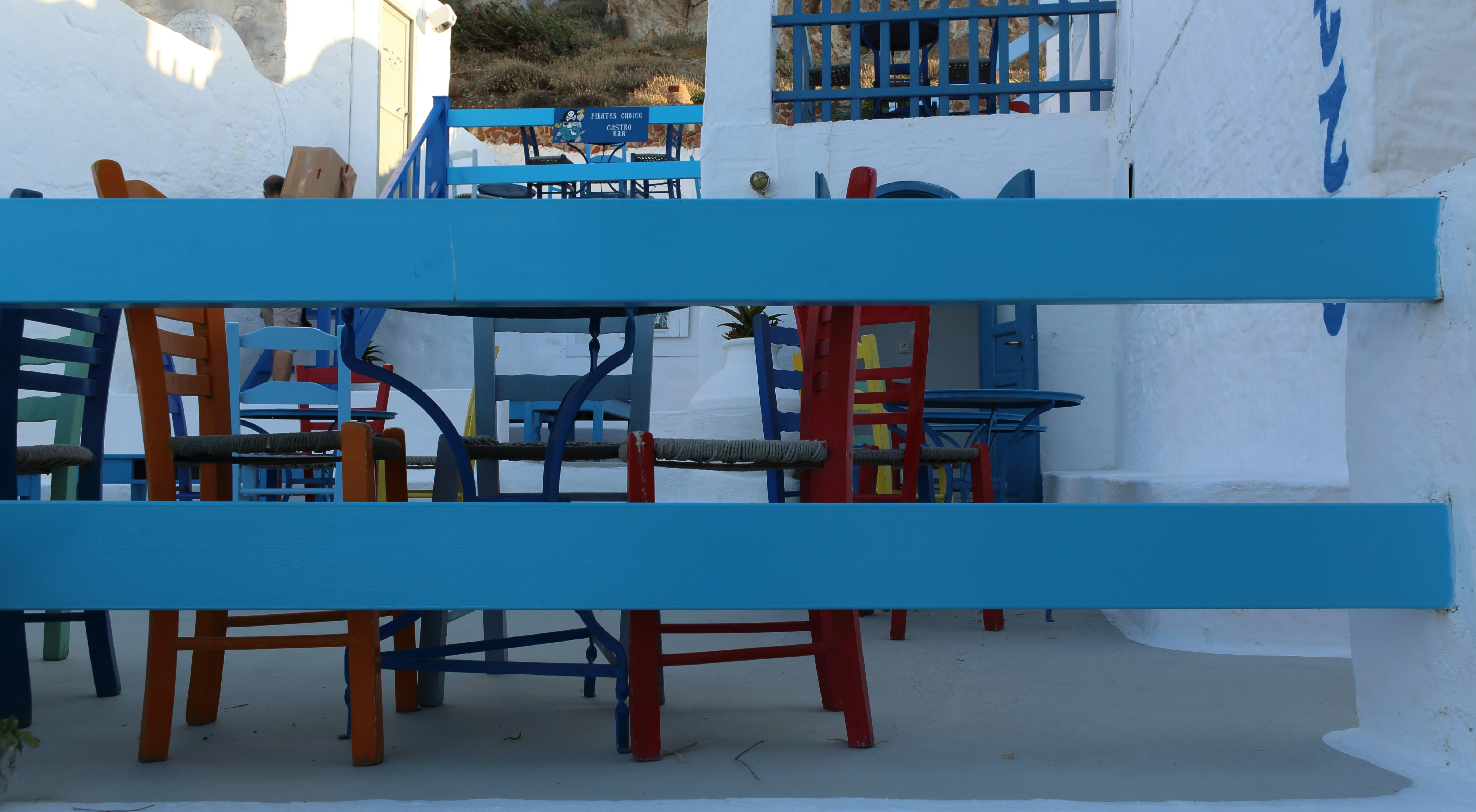A blue and red table and chairs in front of a white building