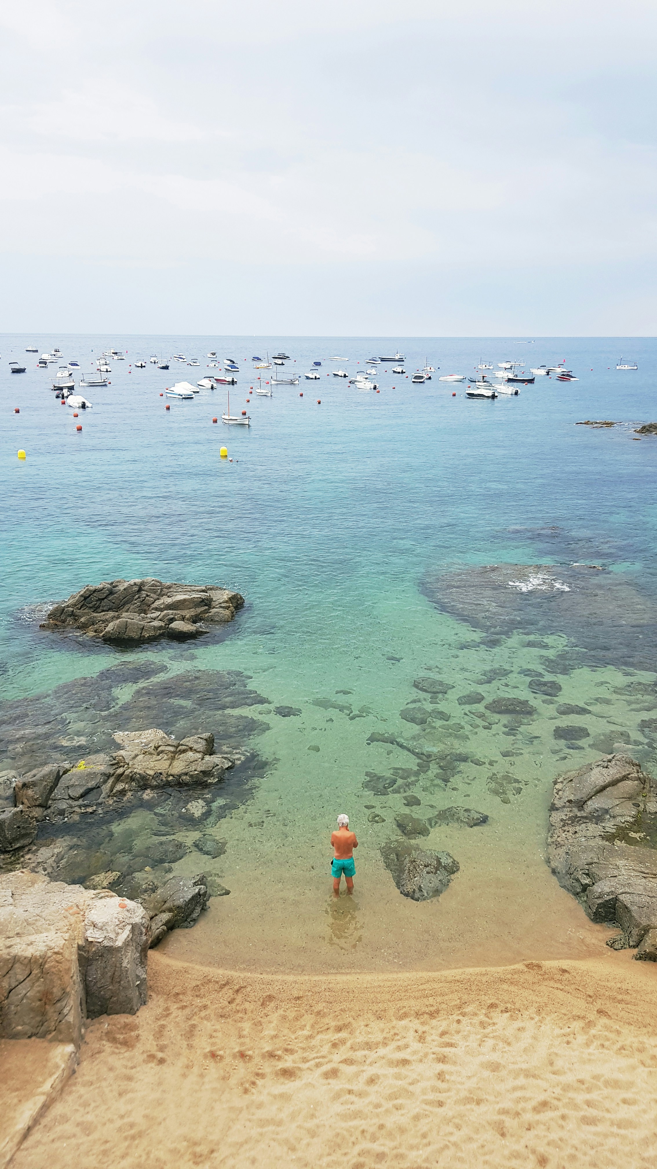 A person standing on a beach next to the ocean