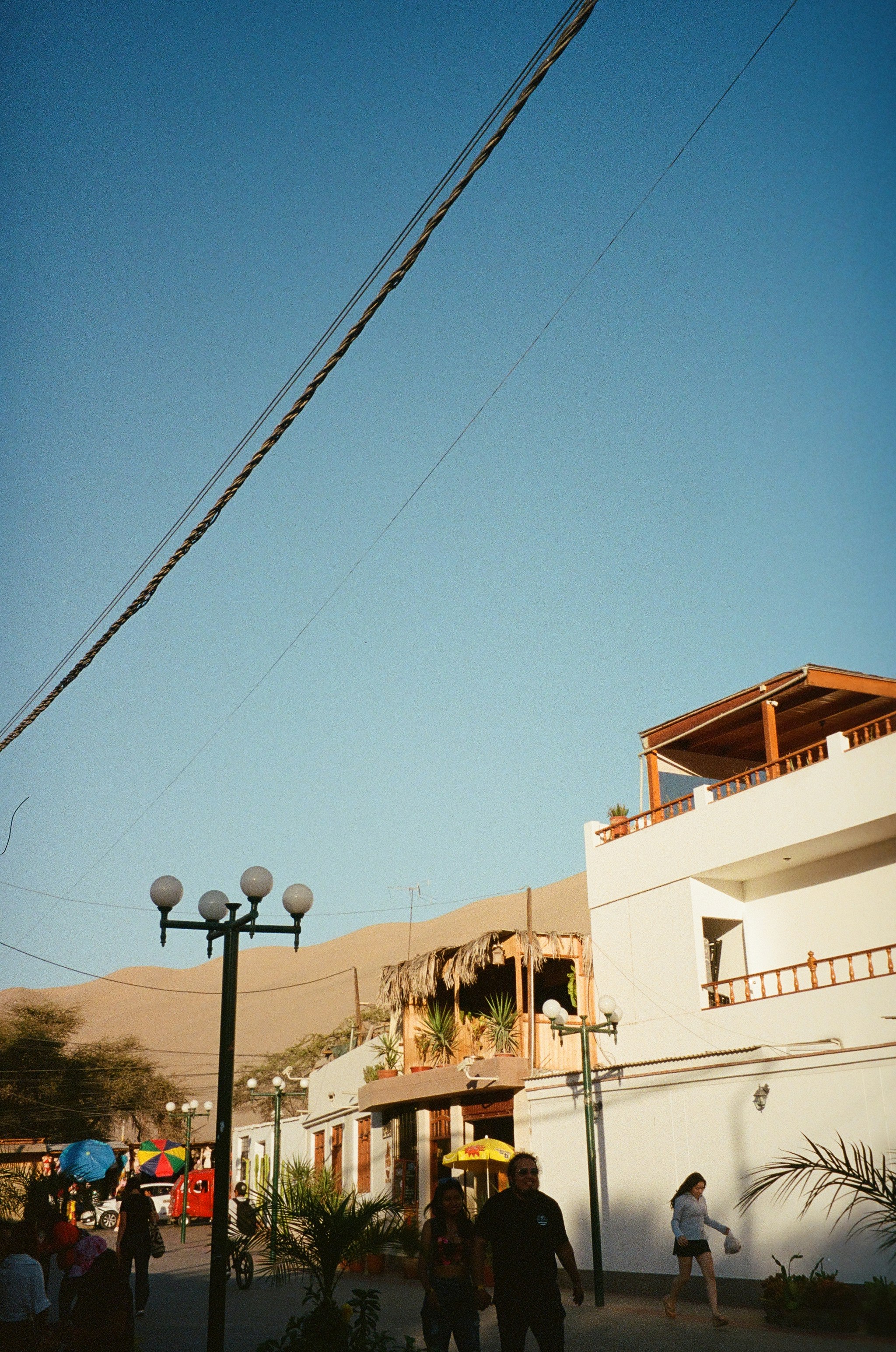 A group of people walking down a street next to tall buildings