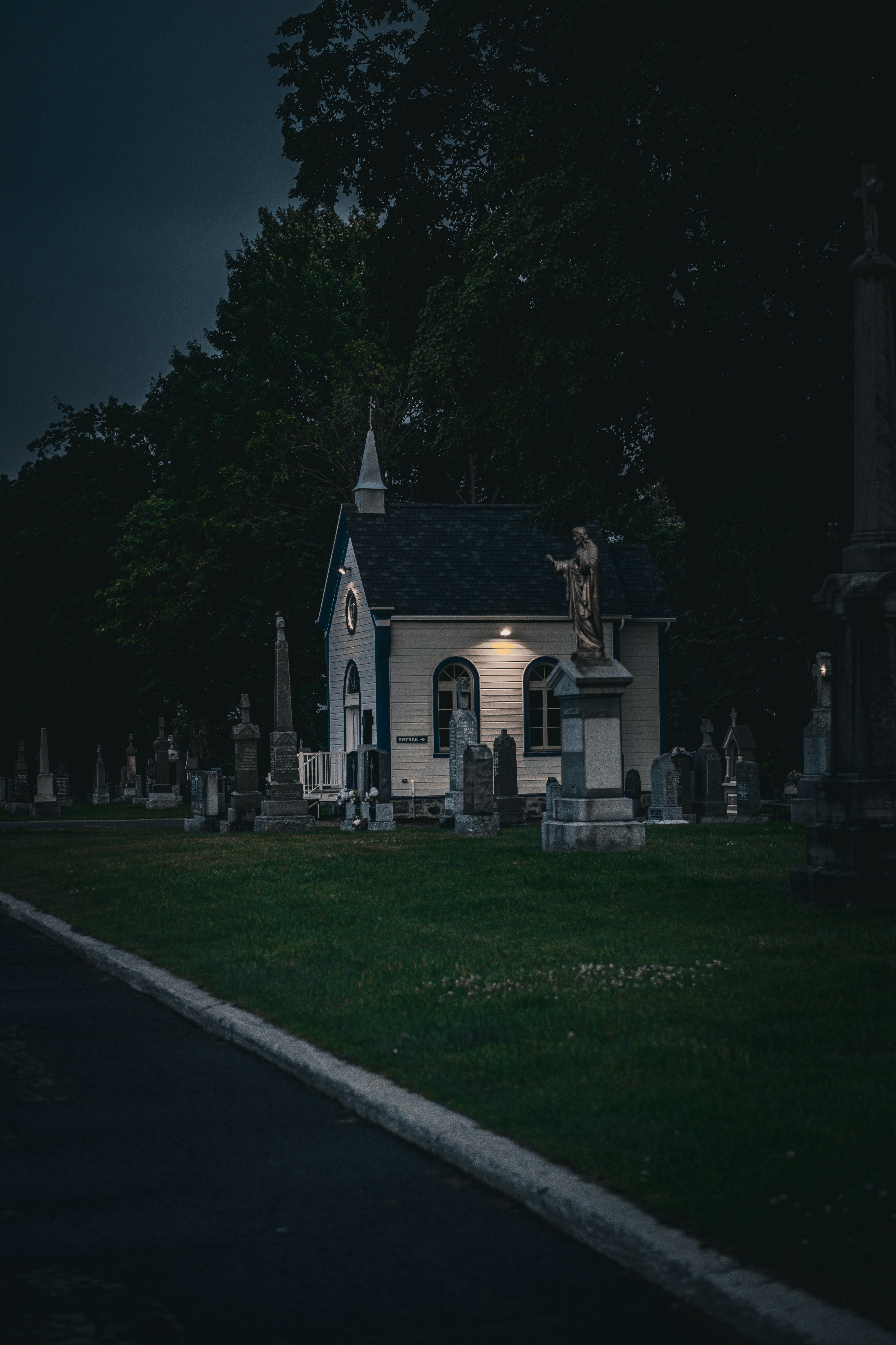 A cemetery at night with a lit up church