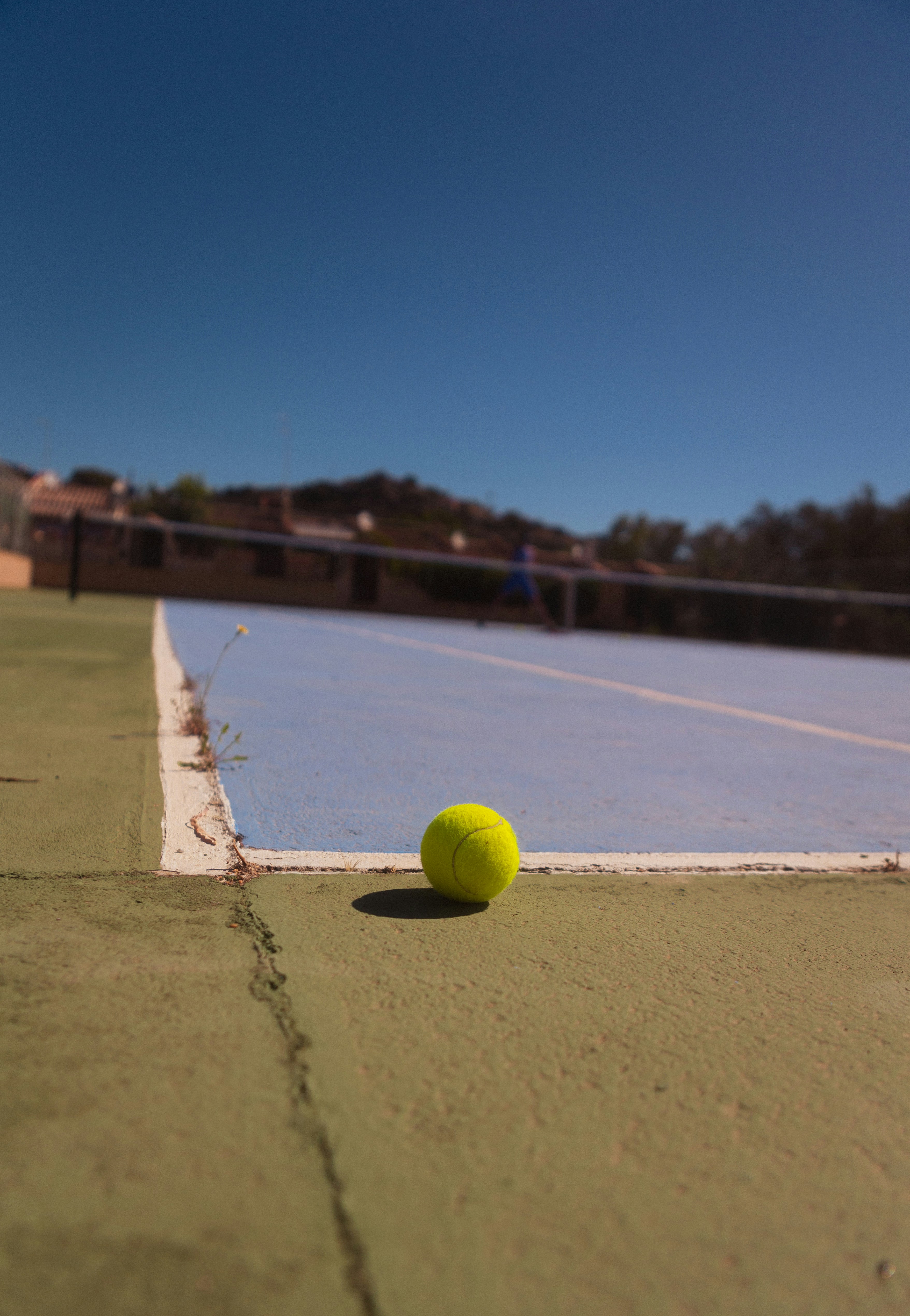 A tennis ball sitting on a tennis court