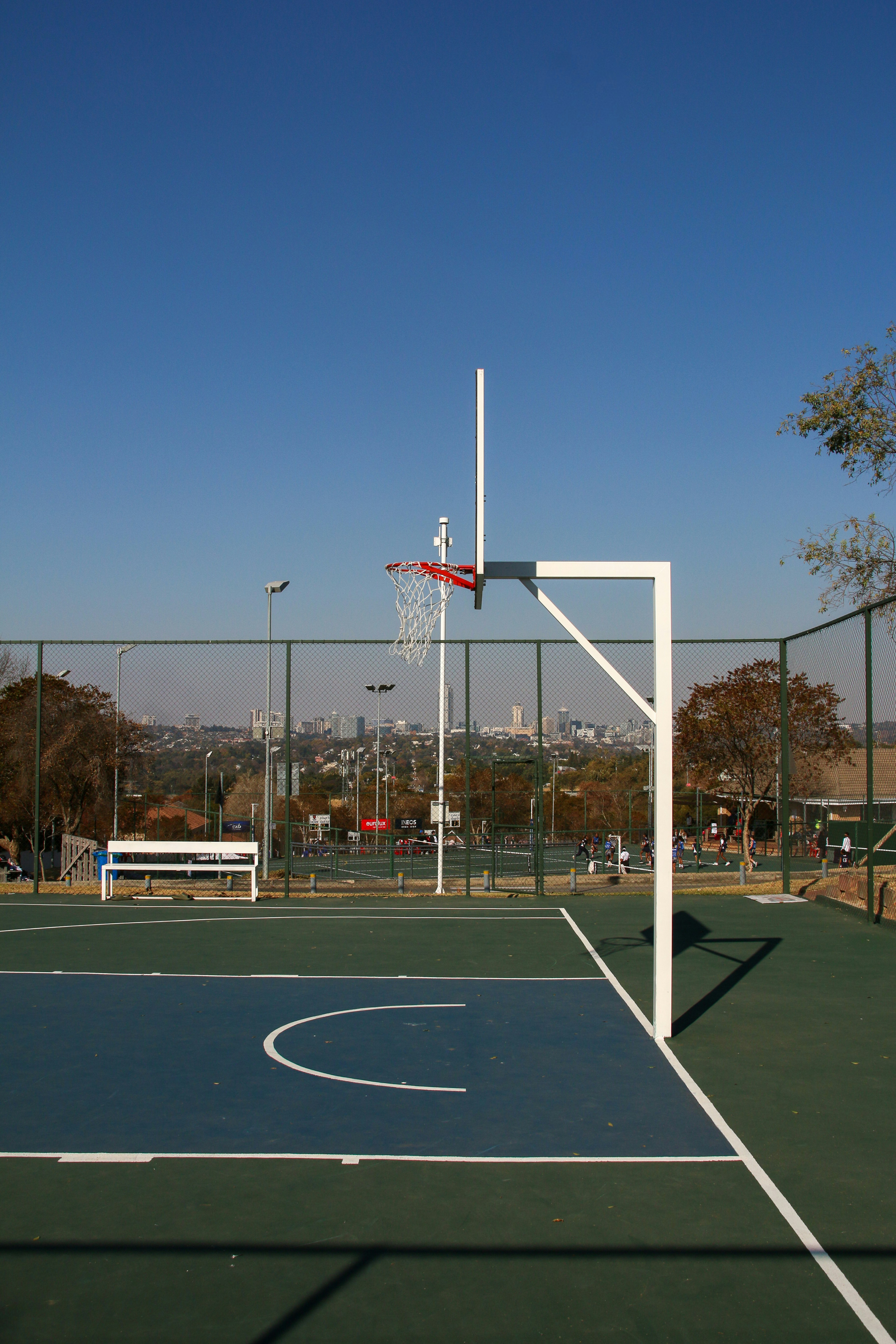 Image of a community basketball court with adjustable hoops and vibrant surface markings