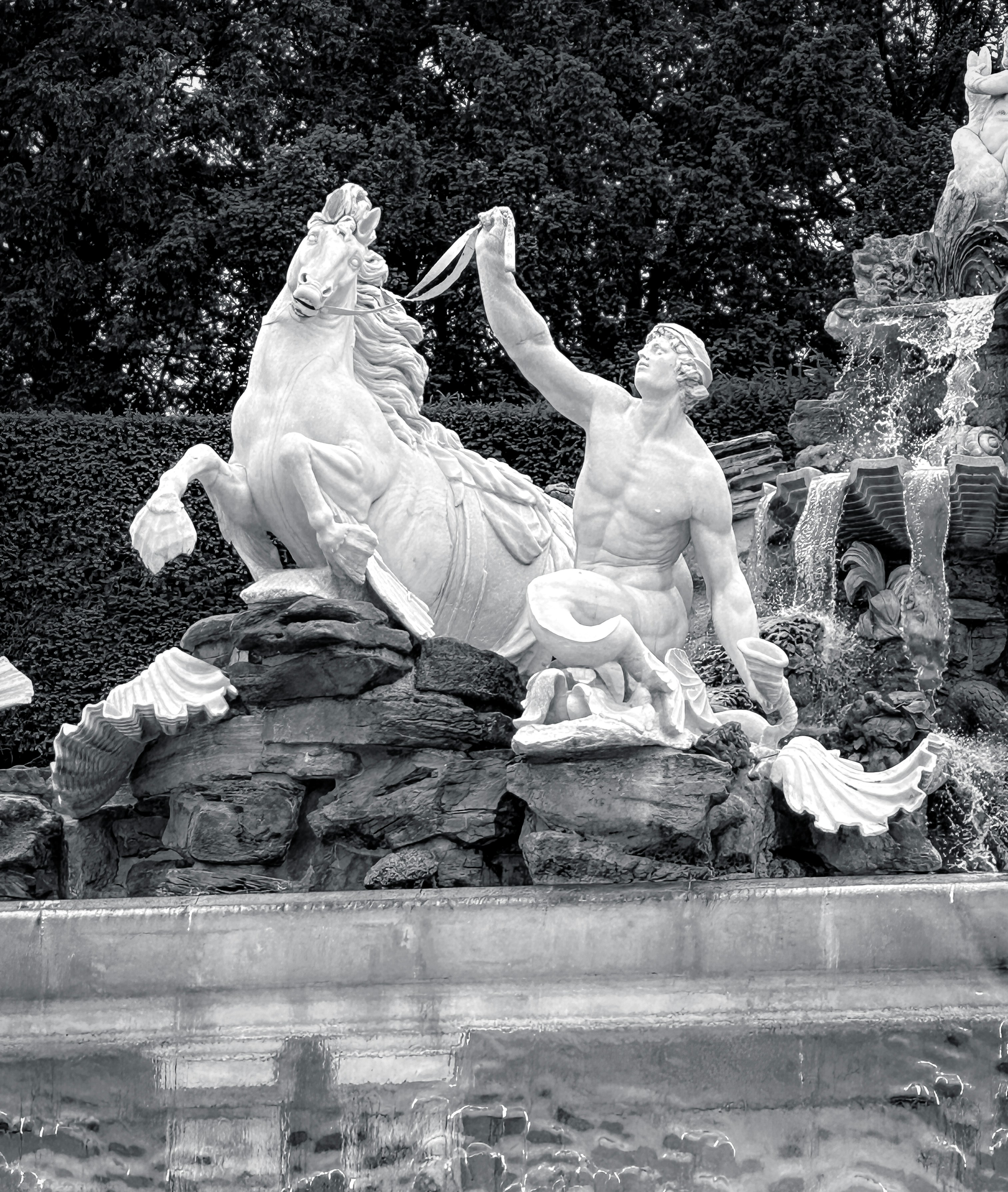 A black and white photo of a fountain with statues