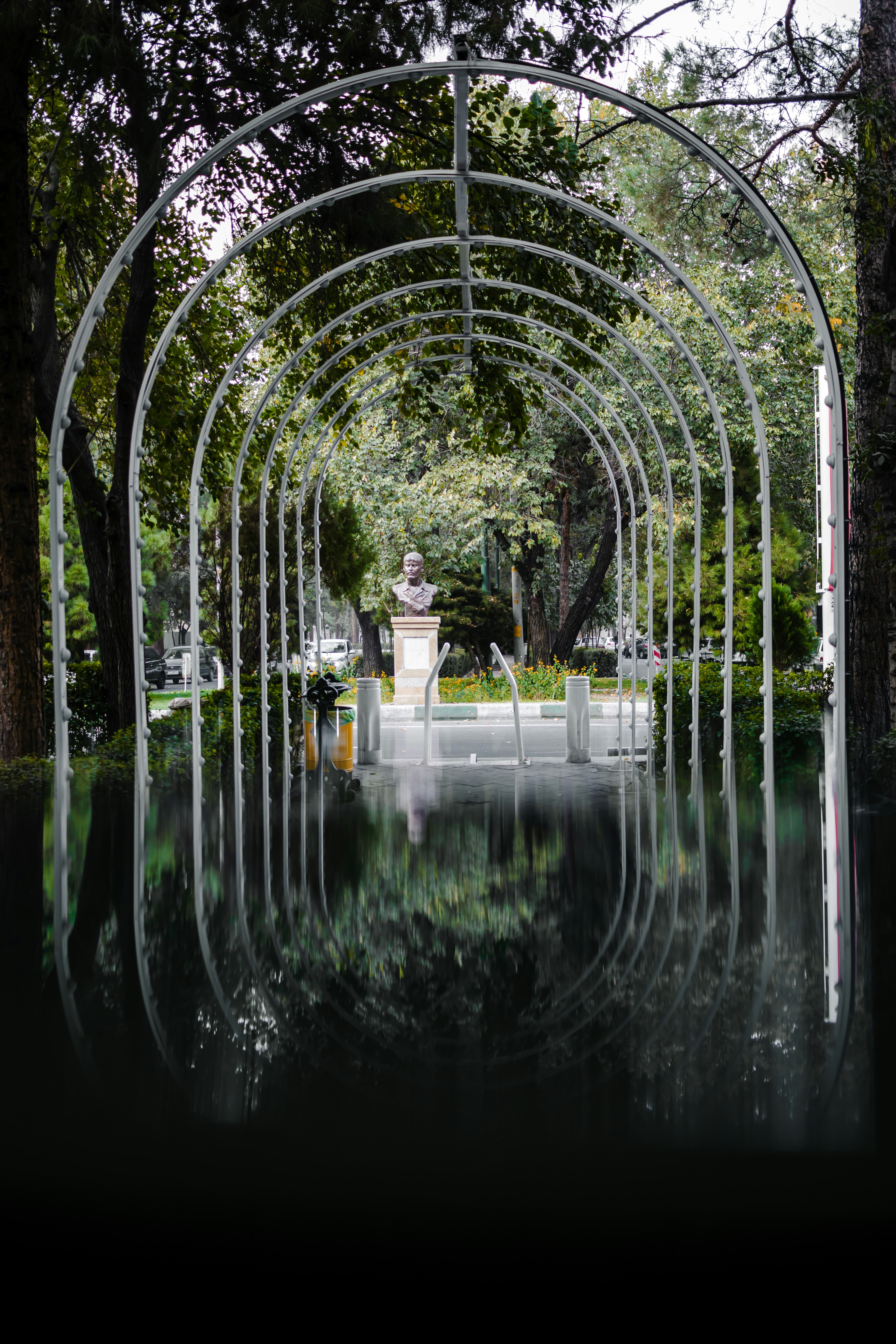 A white arch with a statue in the middle of it