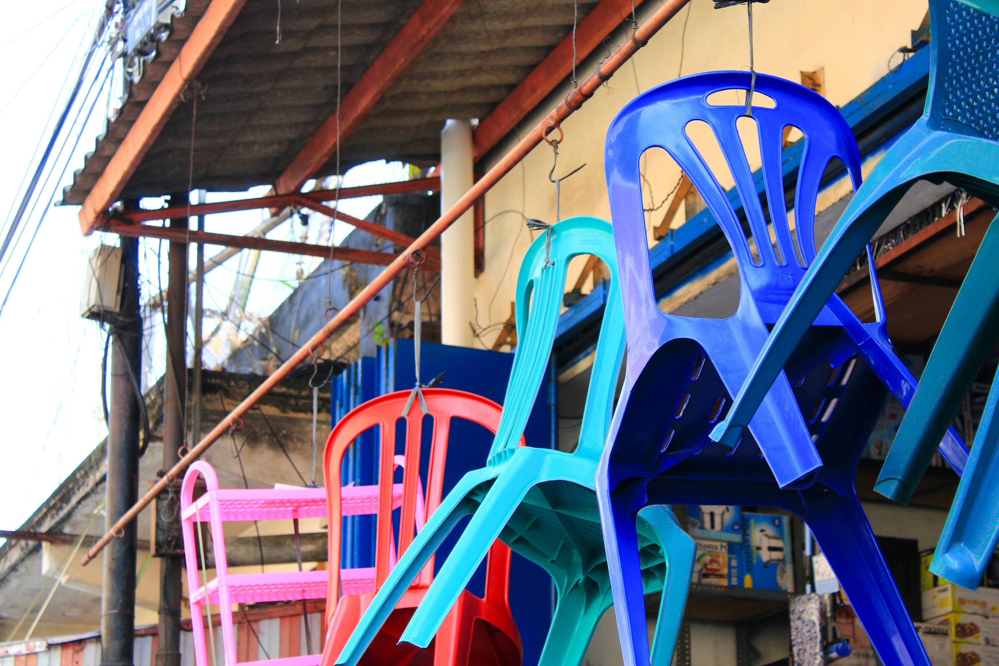 A row of colorful chairs sitting next to a building