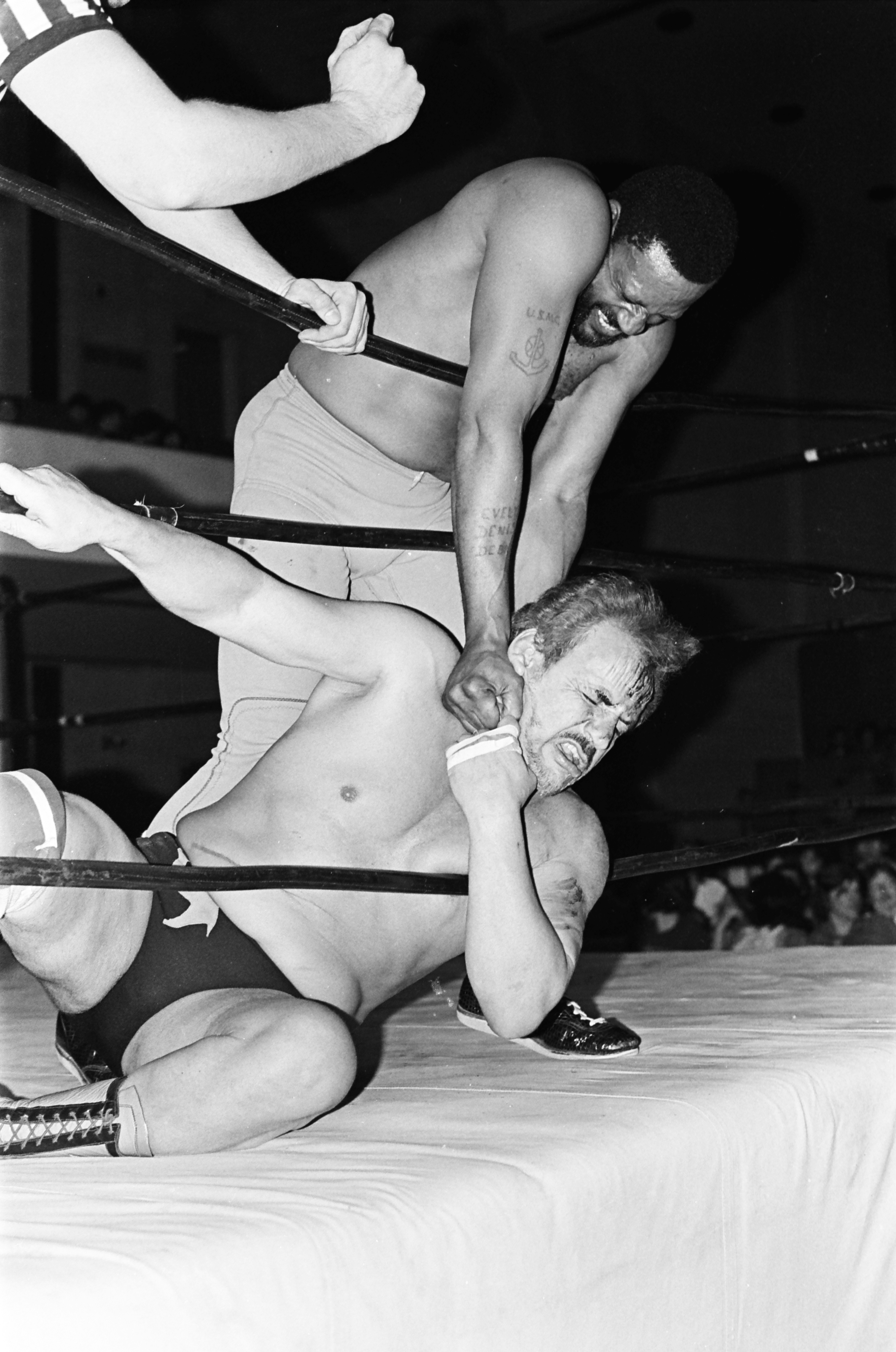Two men wrestling in a ring with ropes