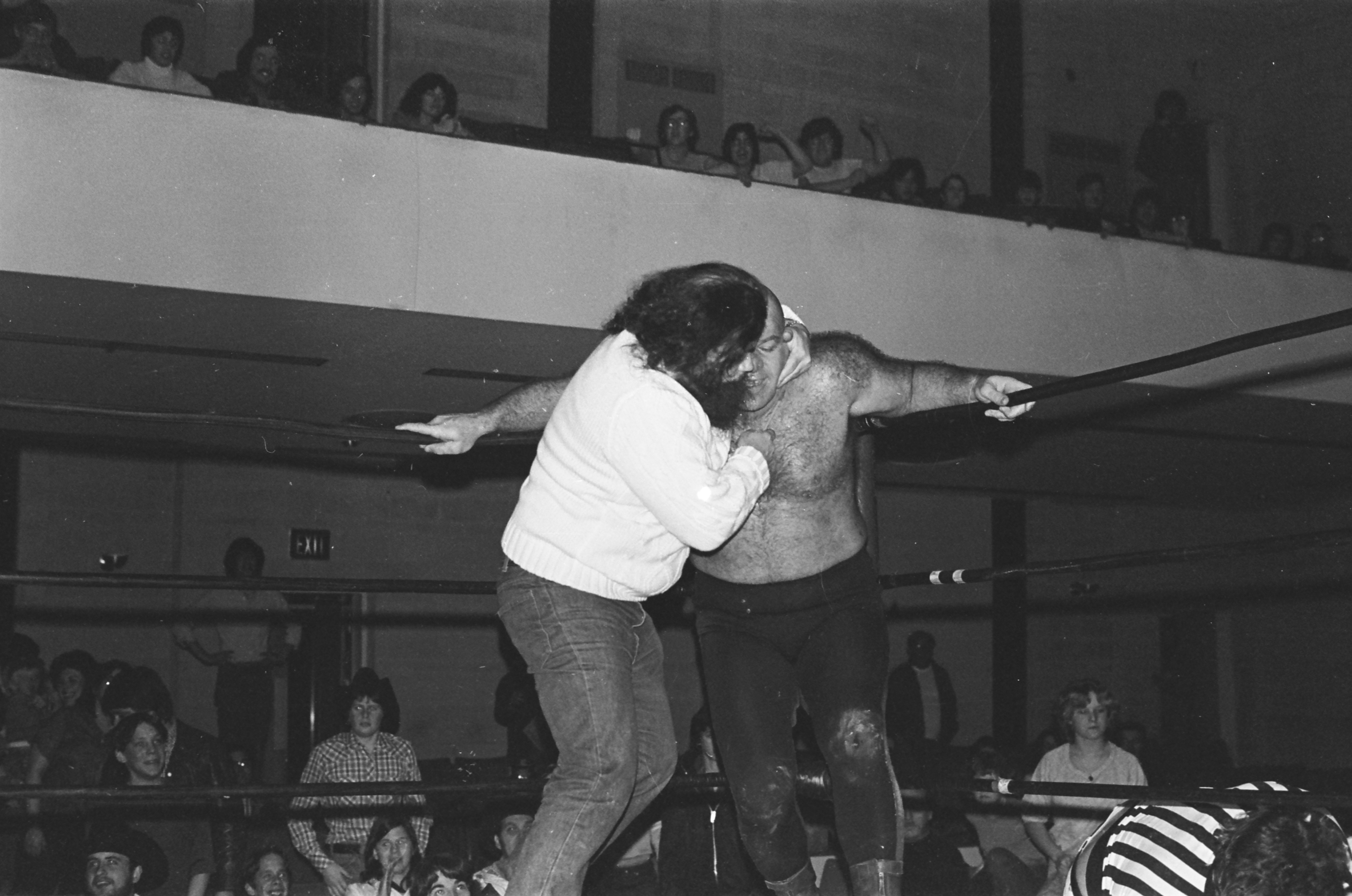 A man on a skateboard performing a trick in front of a crowd