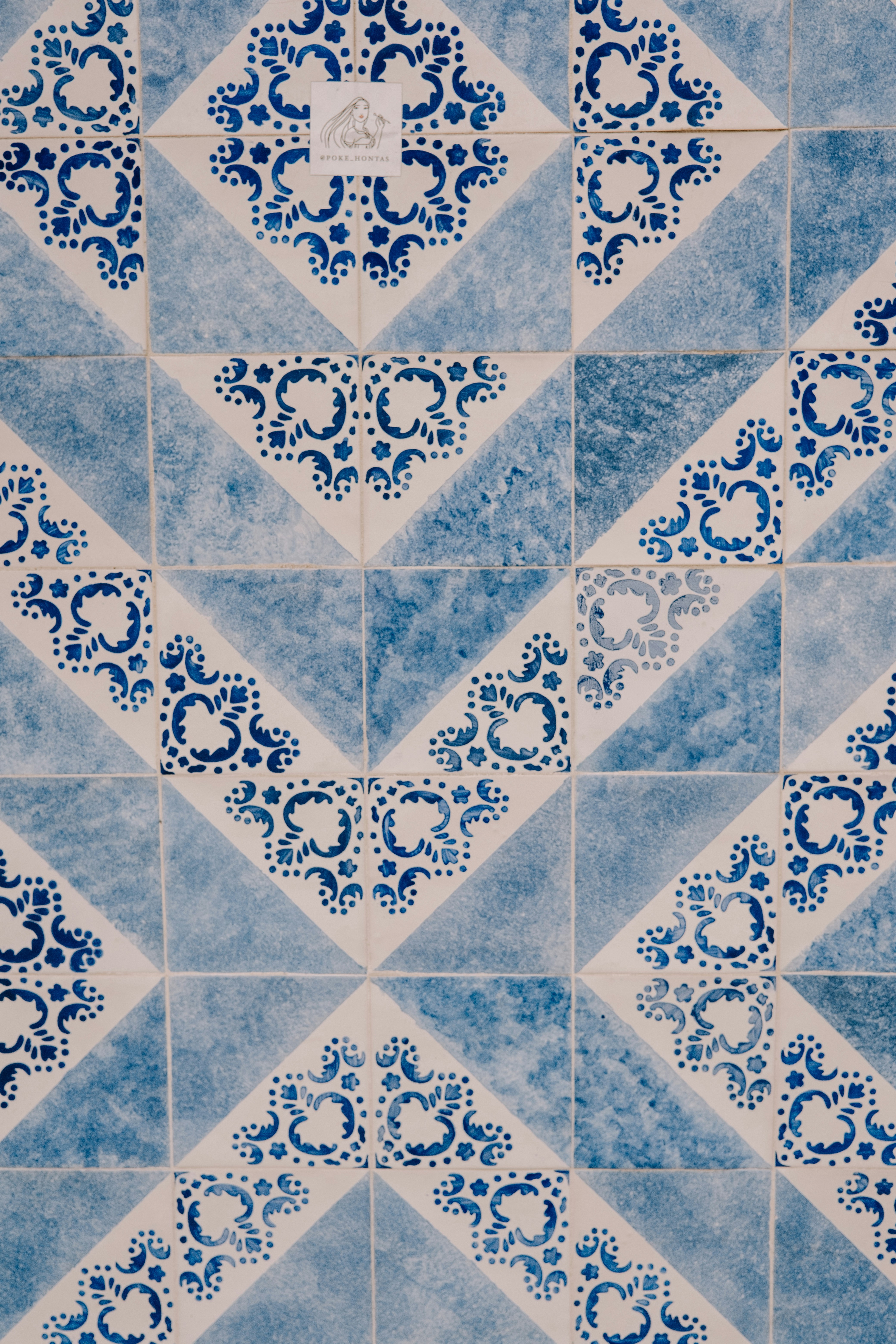 A blue and white tiled wall with a diamond design