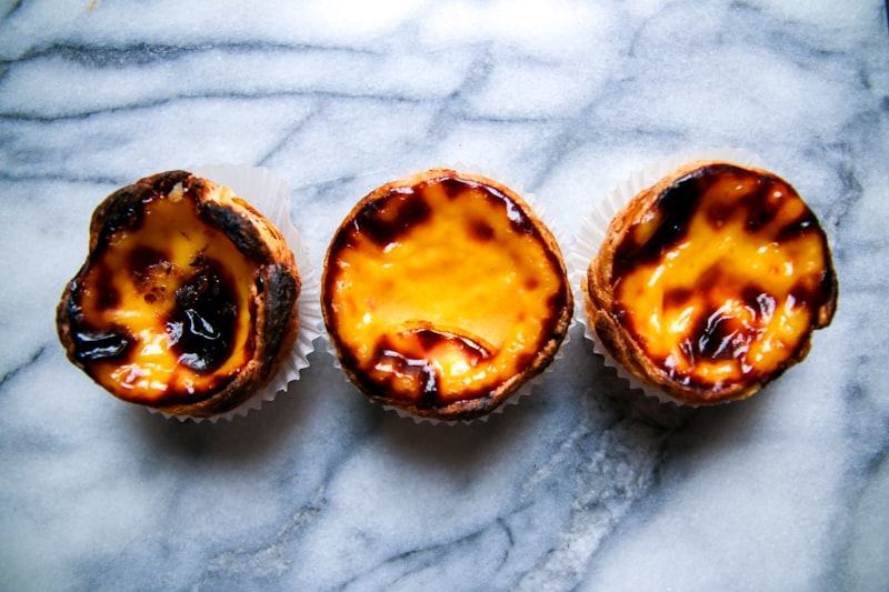 Three desserts sitting on top of a marble counter