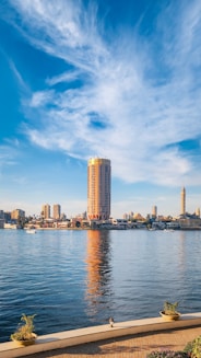 A body of water with a city in the background