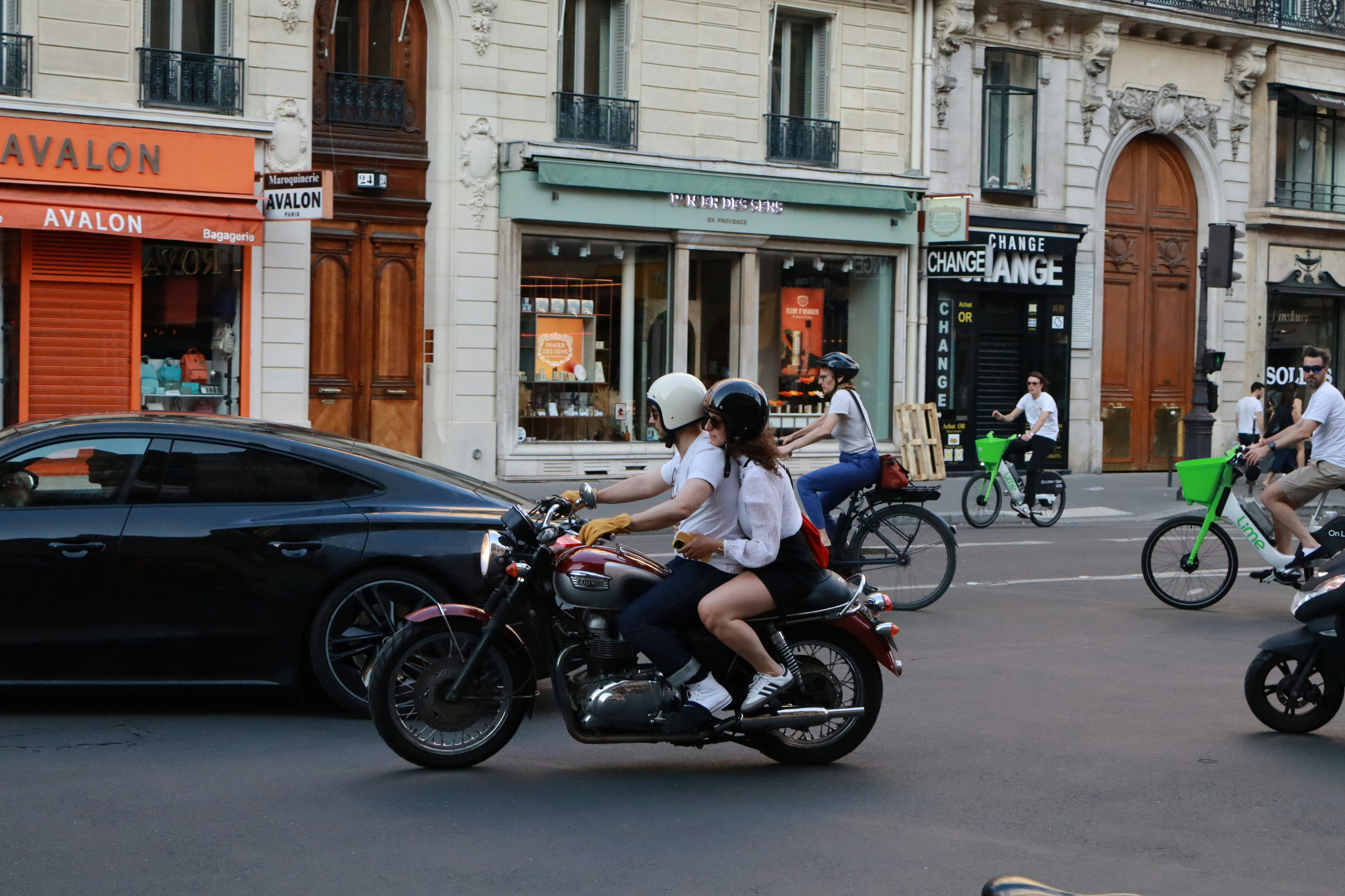 A group of people riding motorcycles down a street