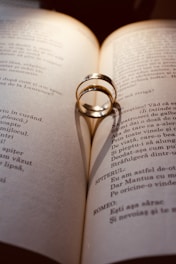 A wedding ring casts a shadow on an open book