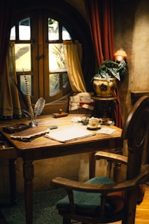 A desk with a chair and a lamp on it