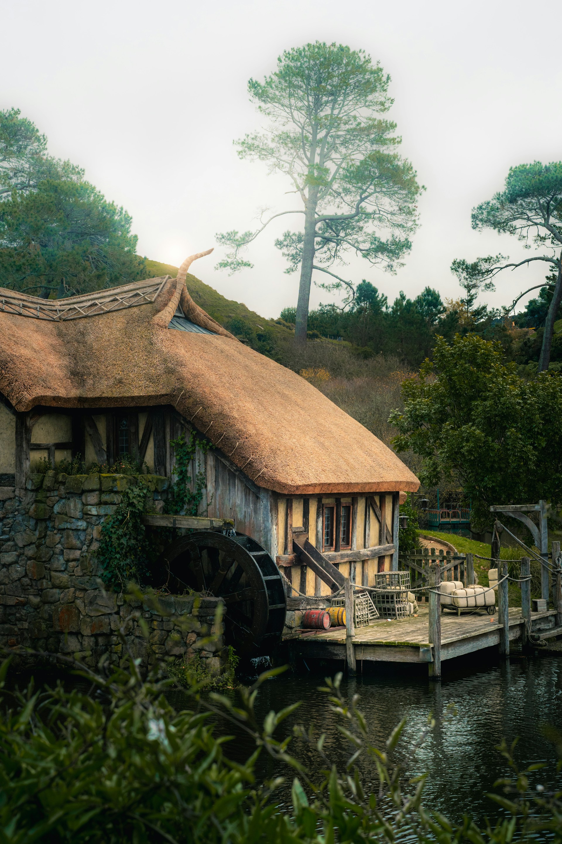 A house with a thatched roof next to a body of water