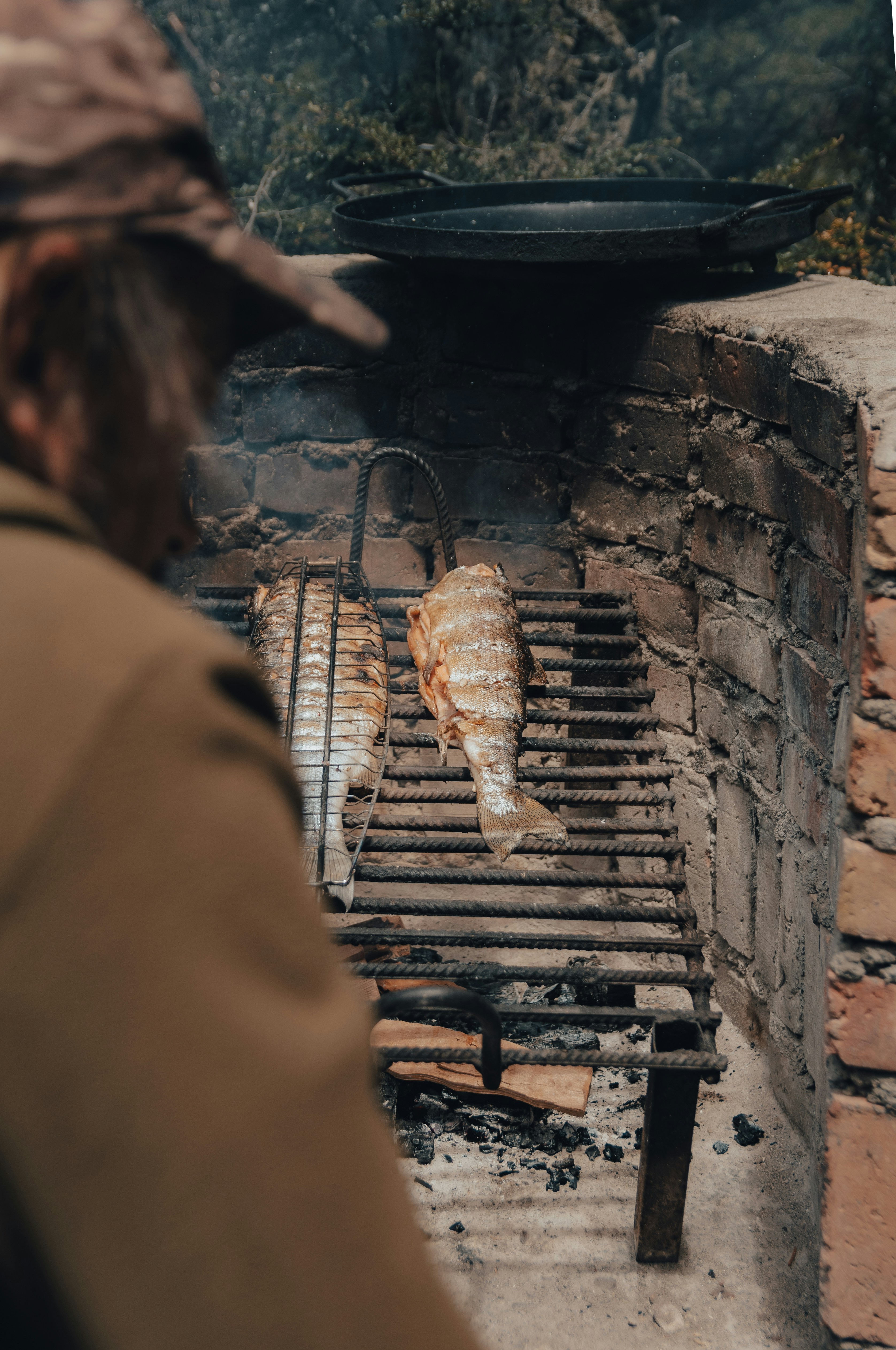 A man standing in front of a brick oven