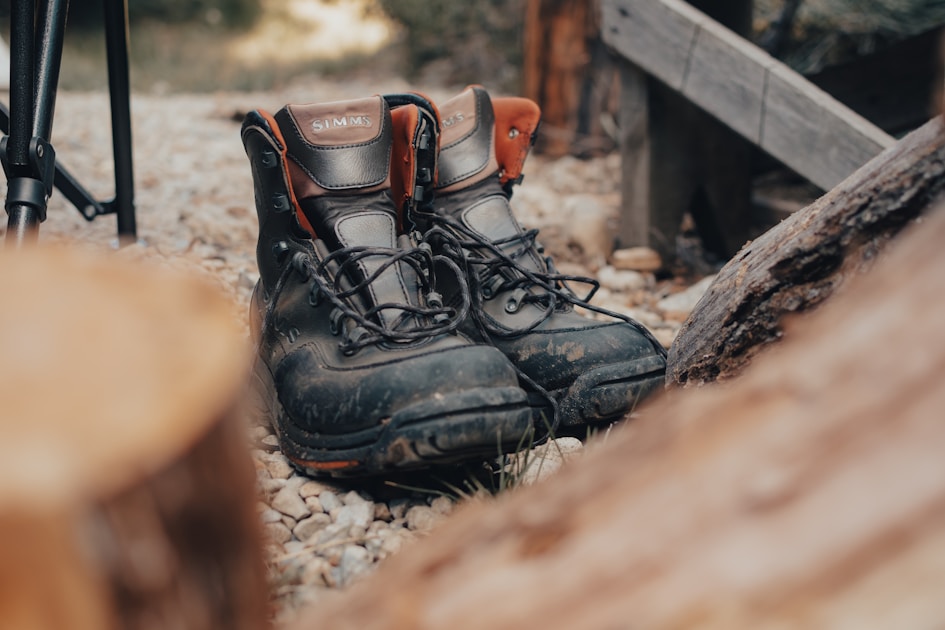 Hunter in tree stand in hardwood forest watching deer trail at dawn