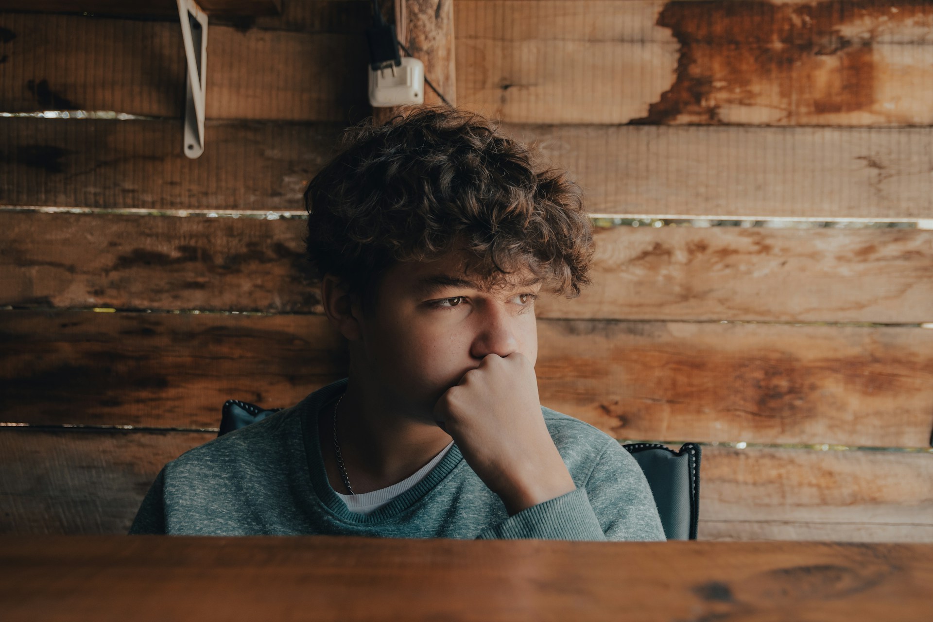A man sitting at a table with his hand on his chin