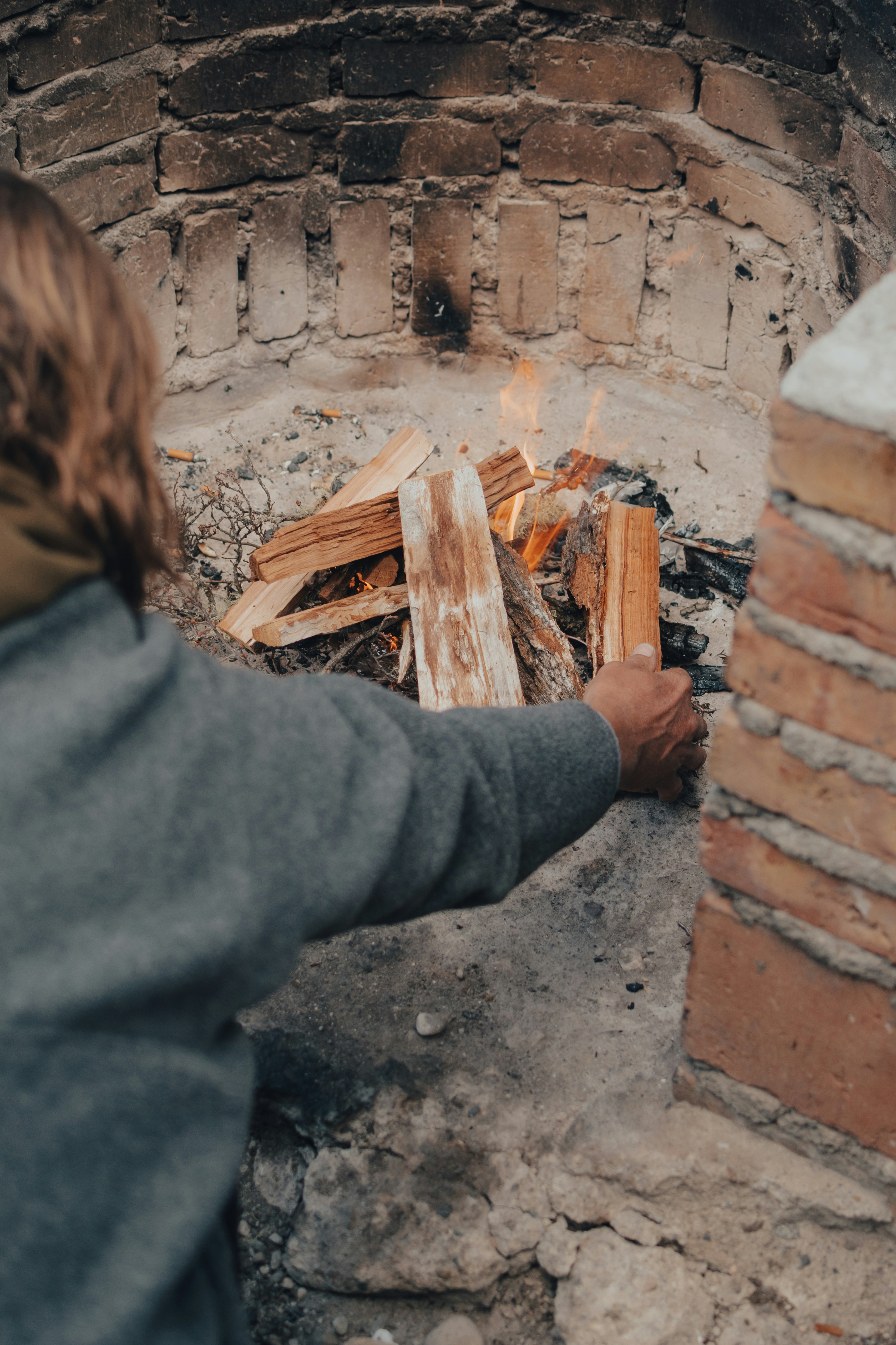 A woman standing in front of a brick oven
