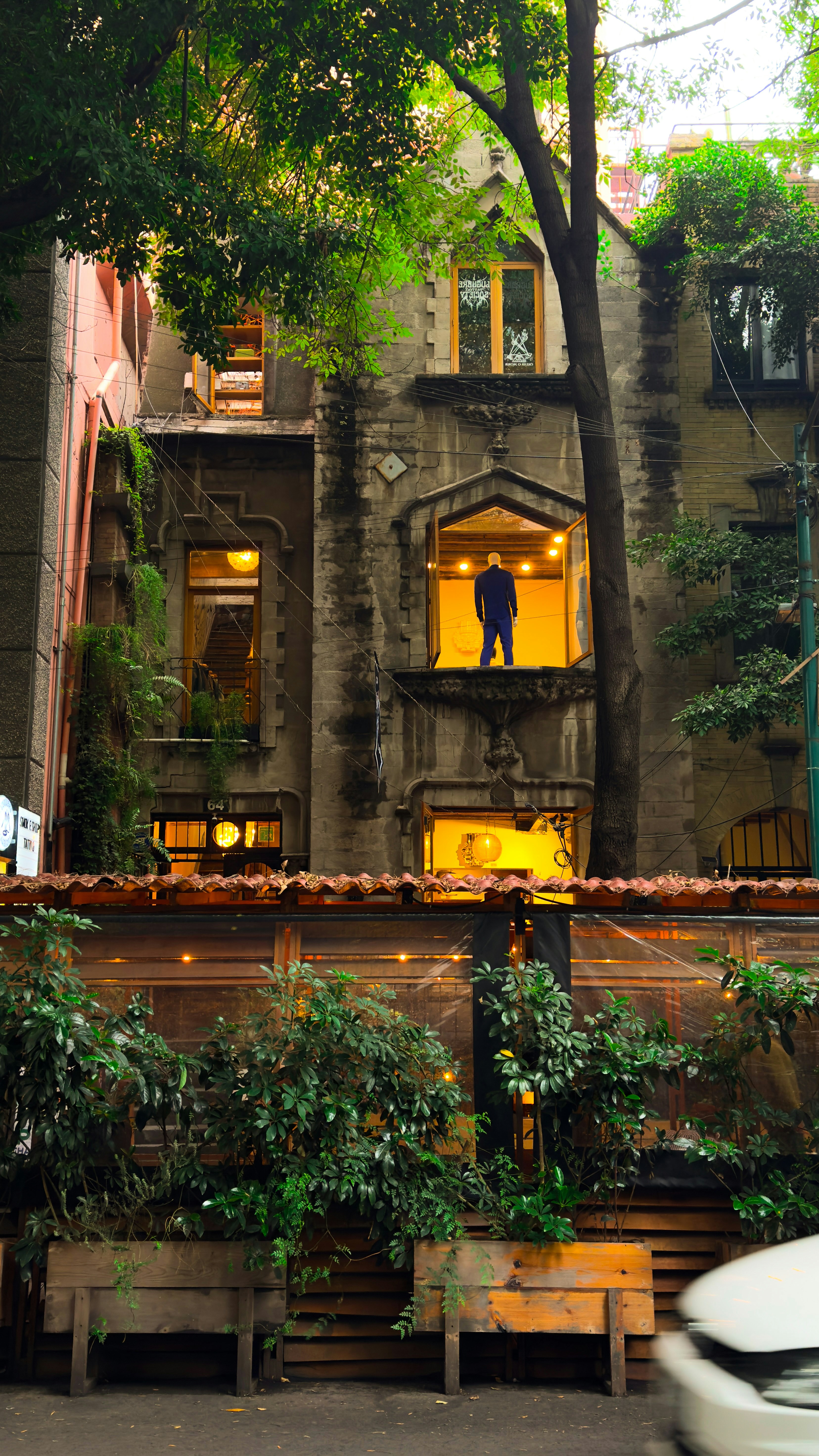 Un coche blanco pasa por delante de un edificio alto