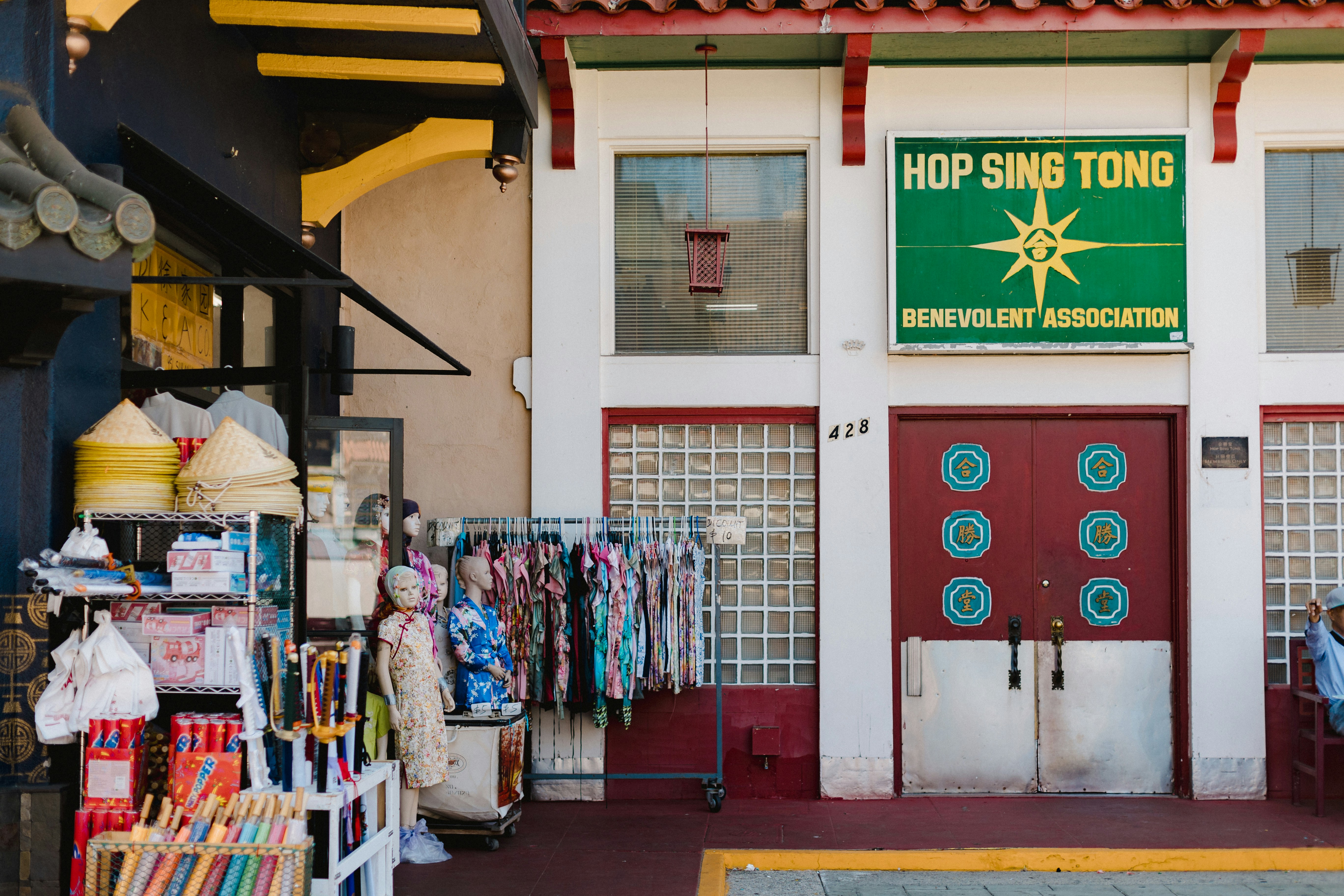A store front with a red door and a green sign