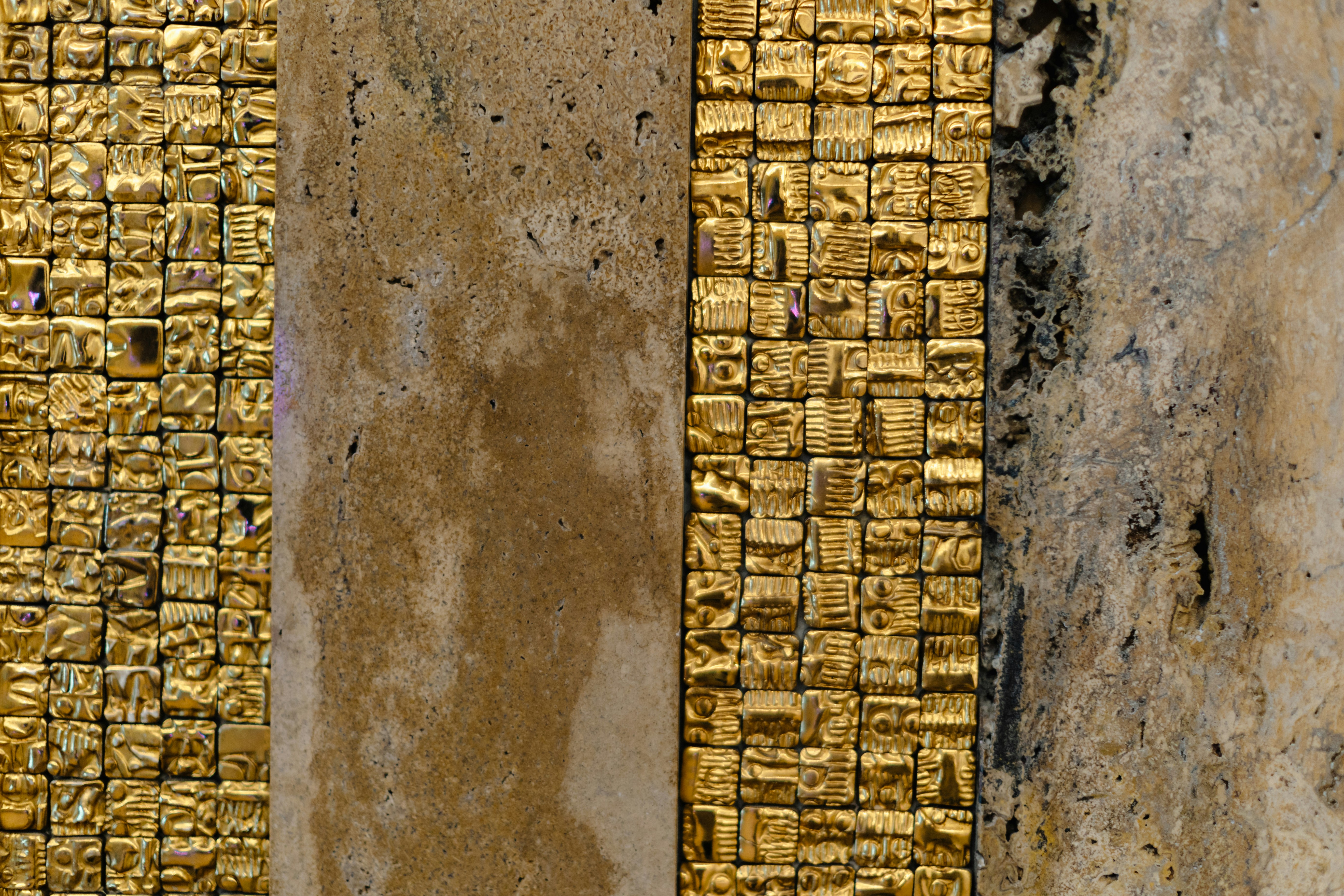 A close up of a brick wall with gold paint