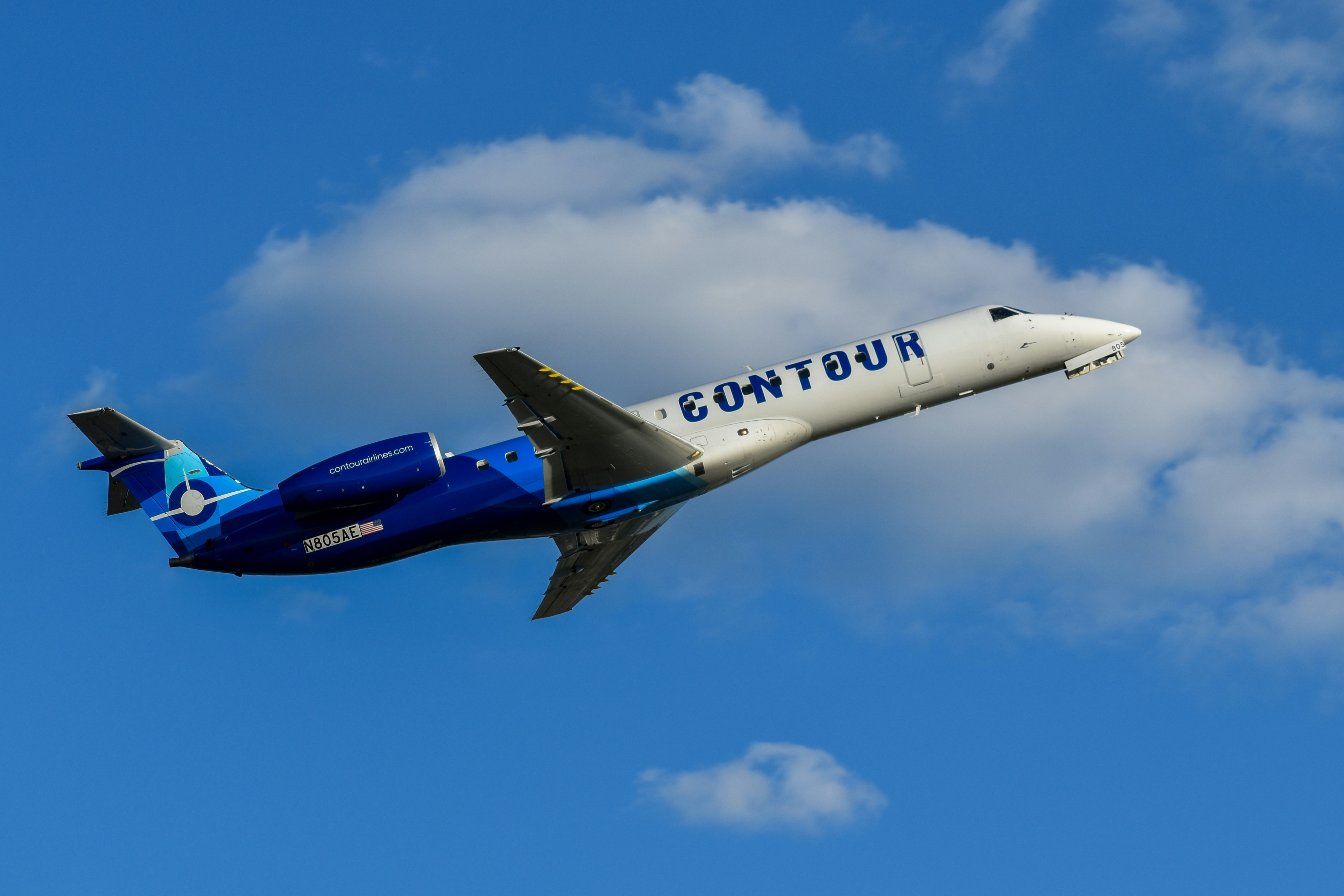 A blue and white airplane flying in the sky, 