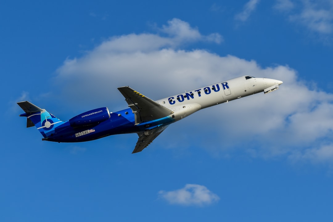 A blue and white airplane flying in the sky,