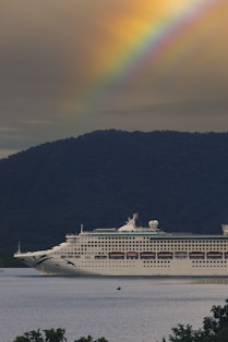 A cruise ship with a rainbow in the background