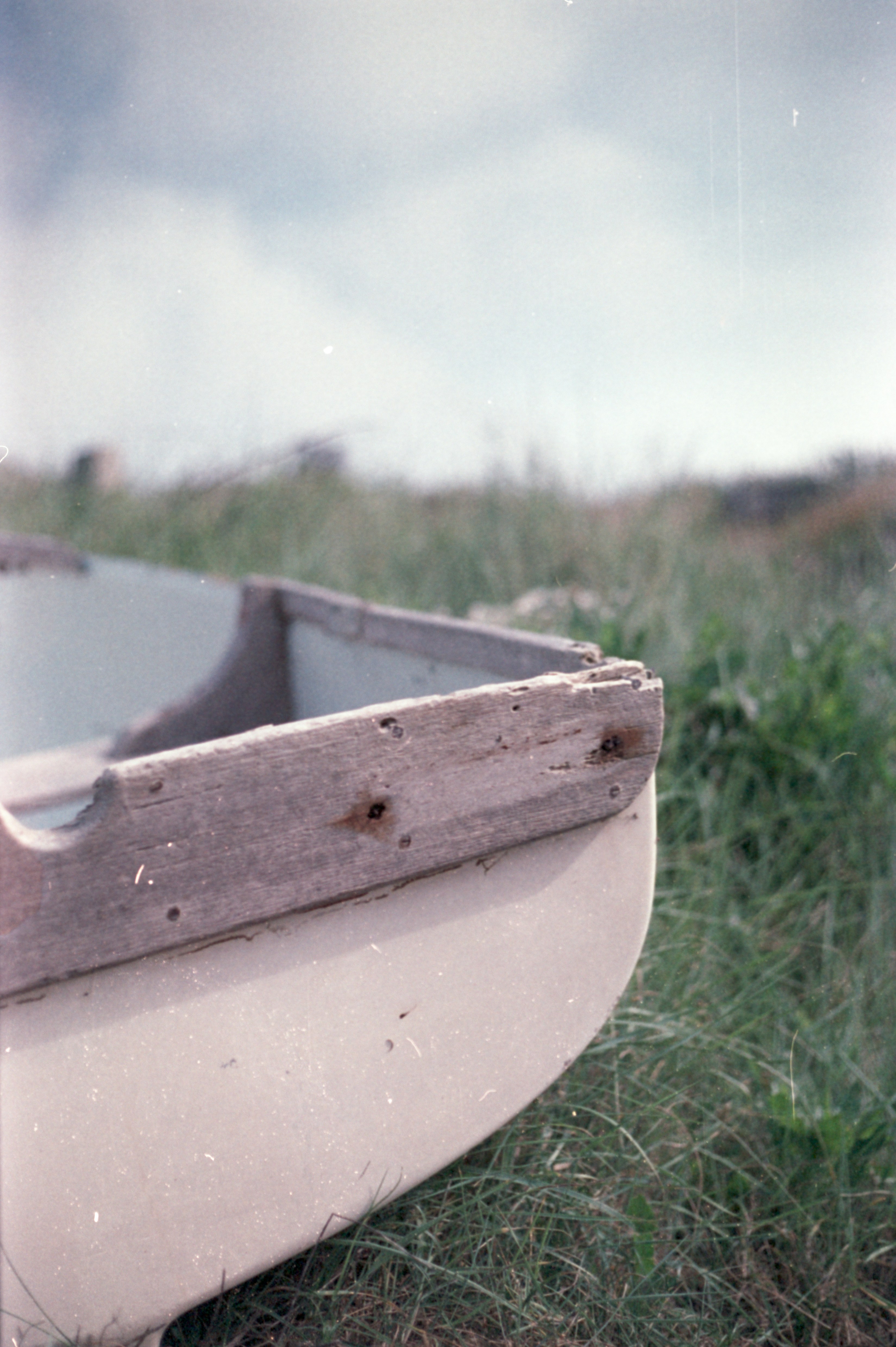 Um barco sentado na grama em um dia nublado