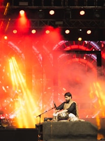A man sitting on a stage with a microphone