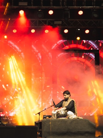 A man sitting on a stage with a microphone