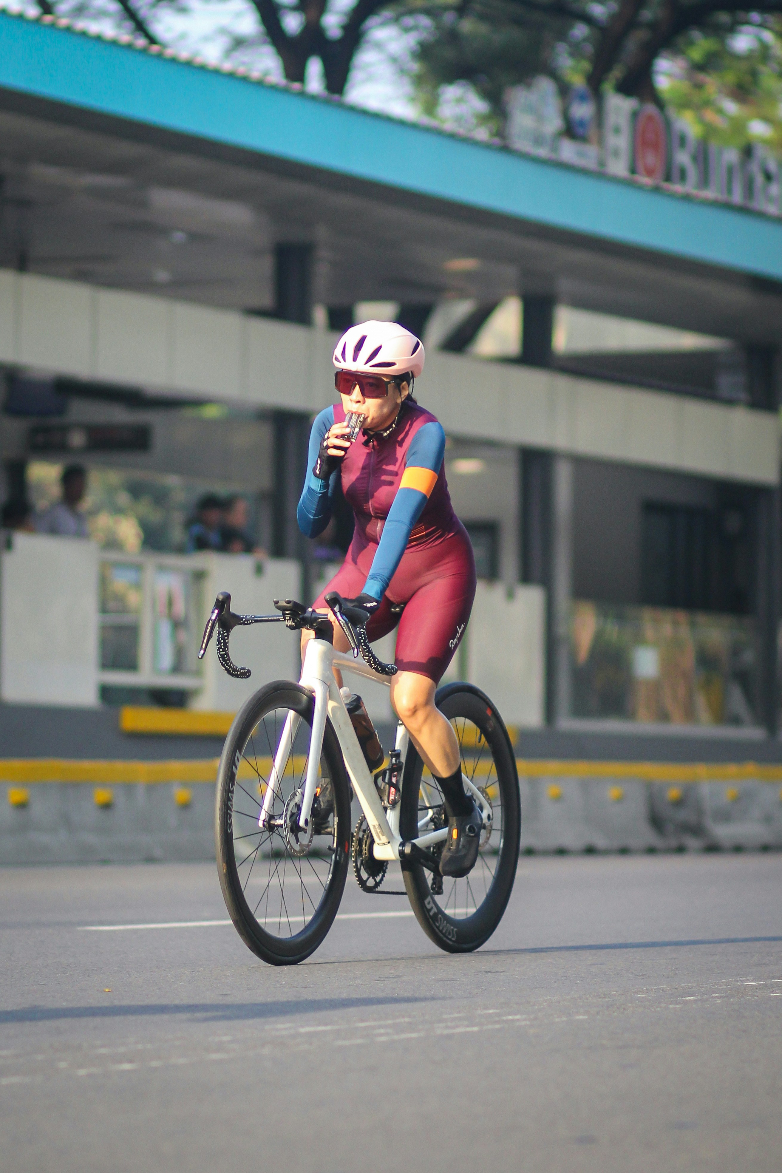 A man riding a bike down a street next to a building