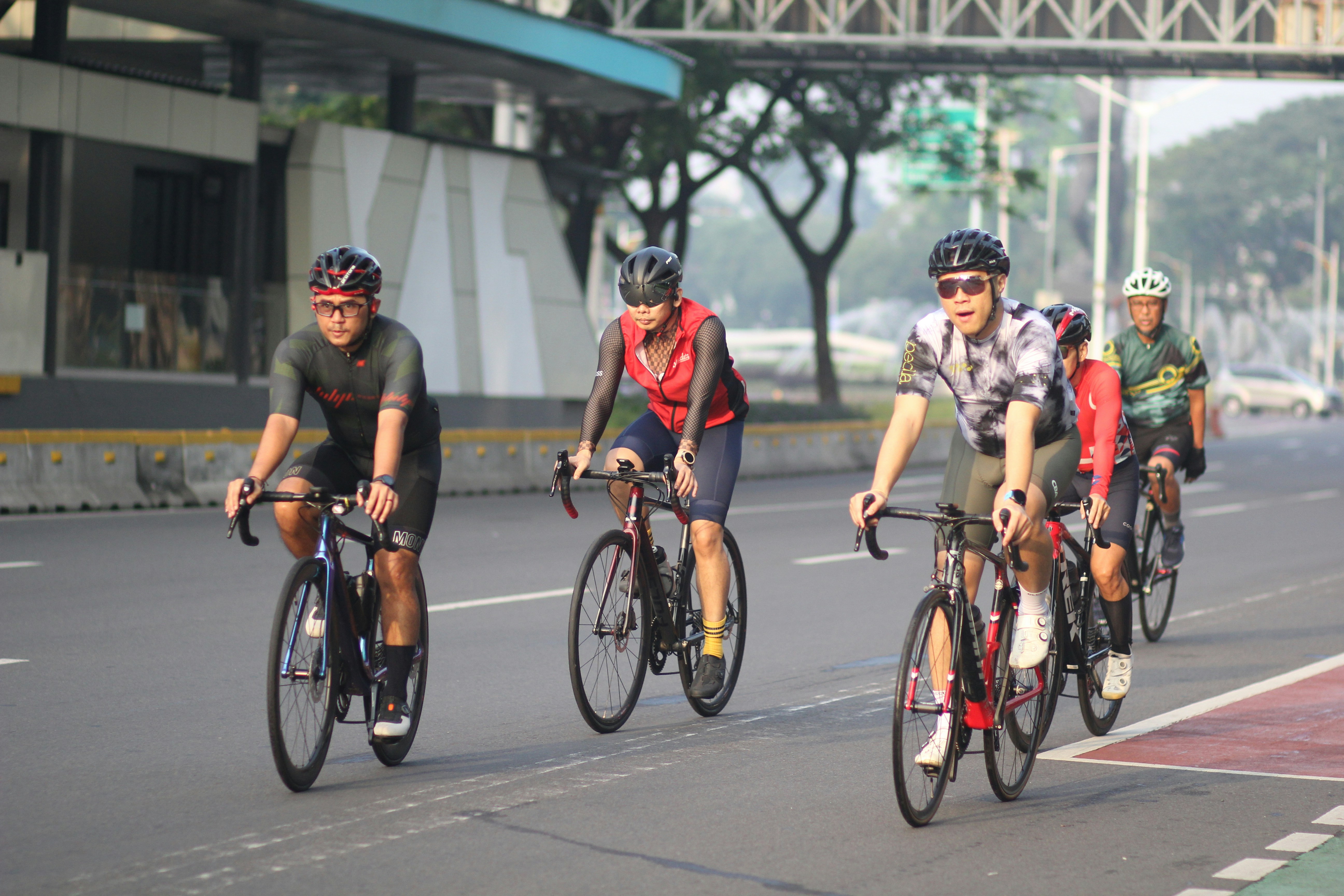A group of people riding bikes down a street