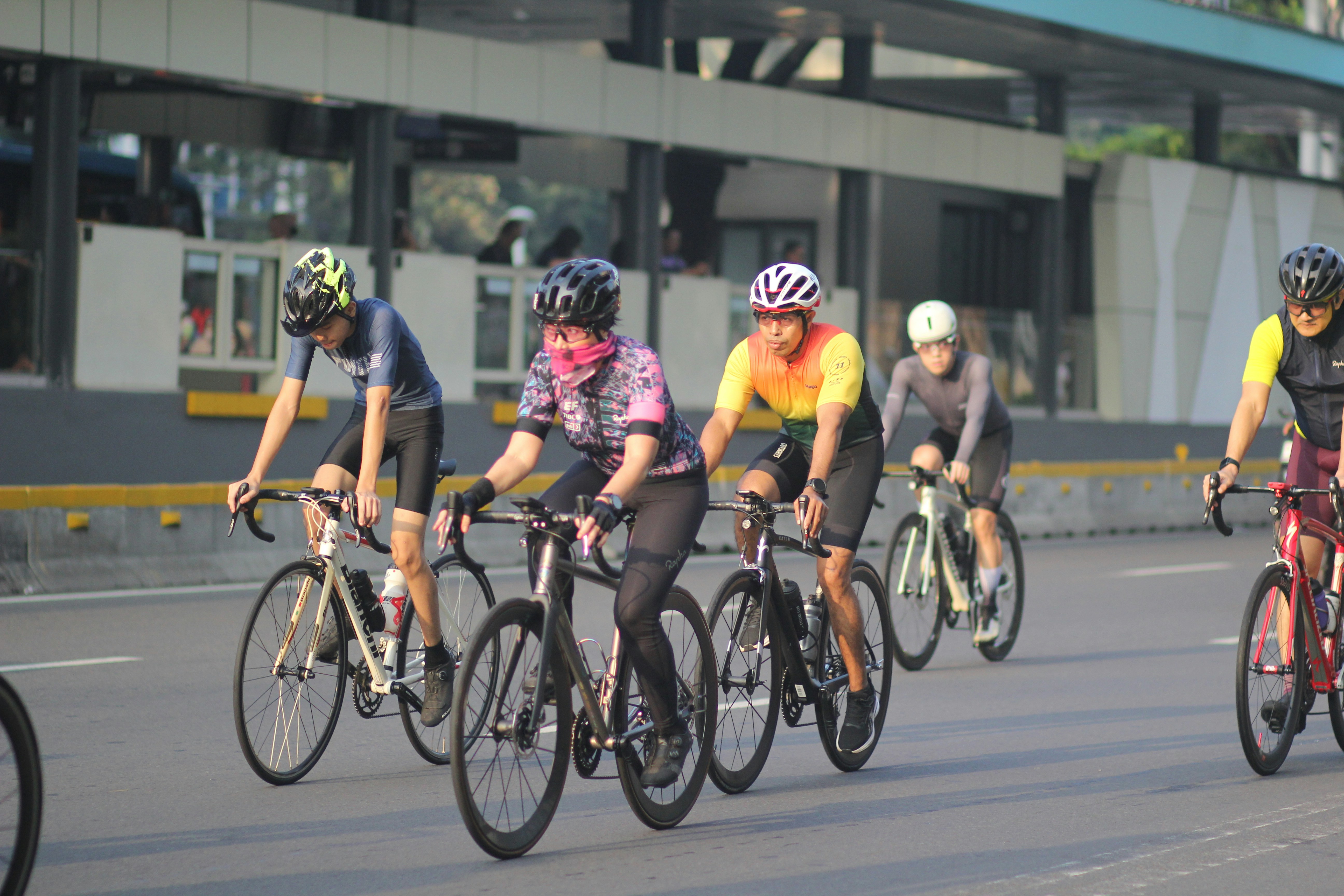 A group of people riding bikes down a street