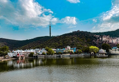 A body of water with a hill in the background