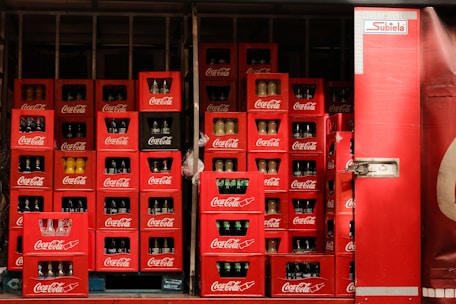 A large display of coca - cola bottles in a store