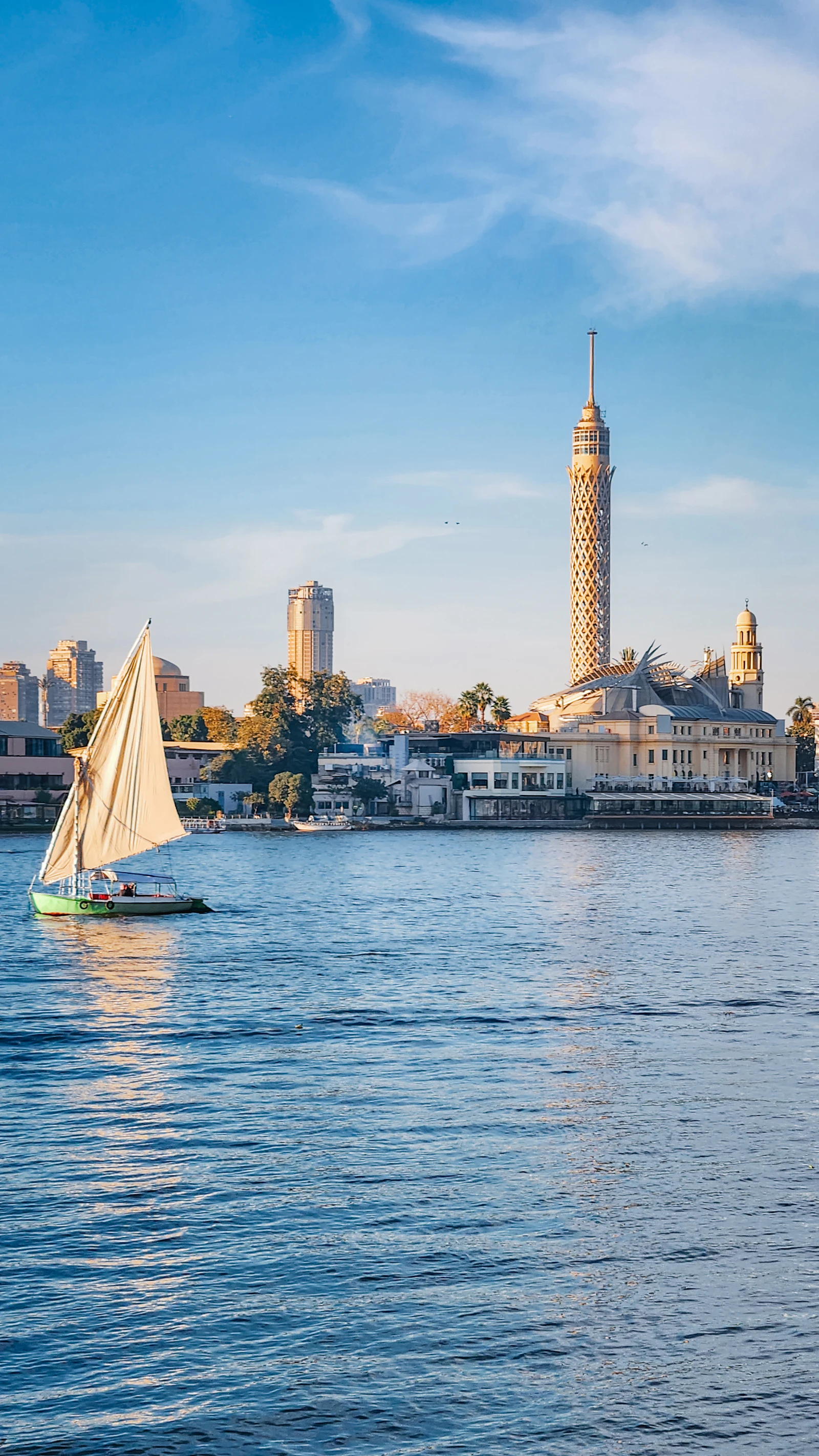 Illustrative image for vegan food in cairo: ful, taameya and koshari: A felucca crossing the Nile with Cairo Tower and the city skyline behind it.