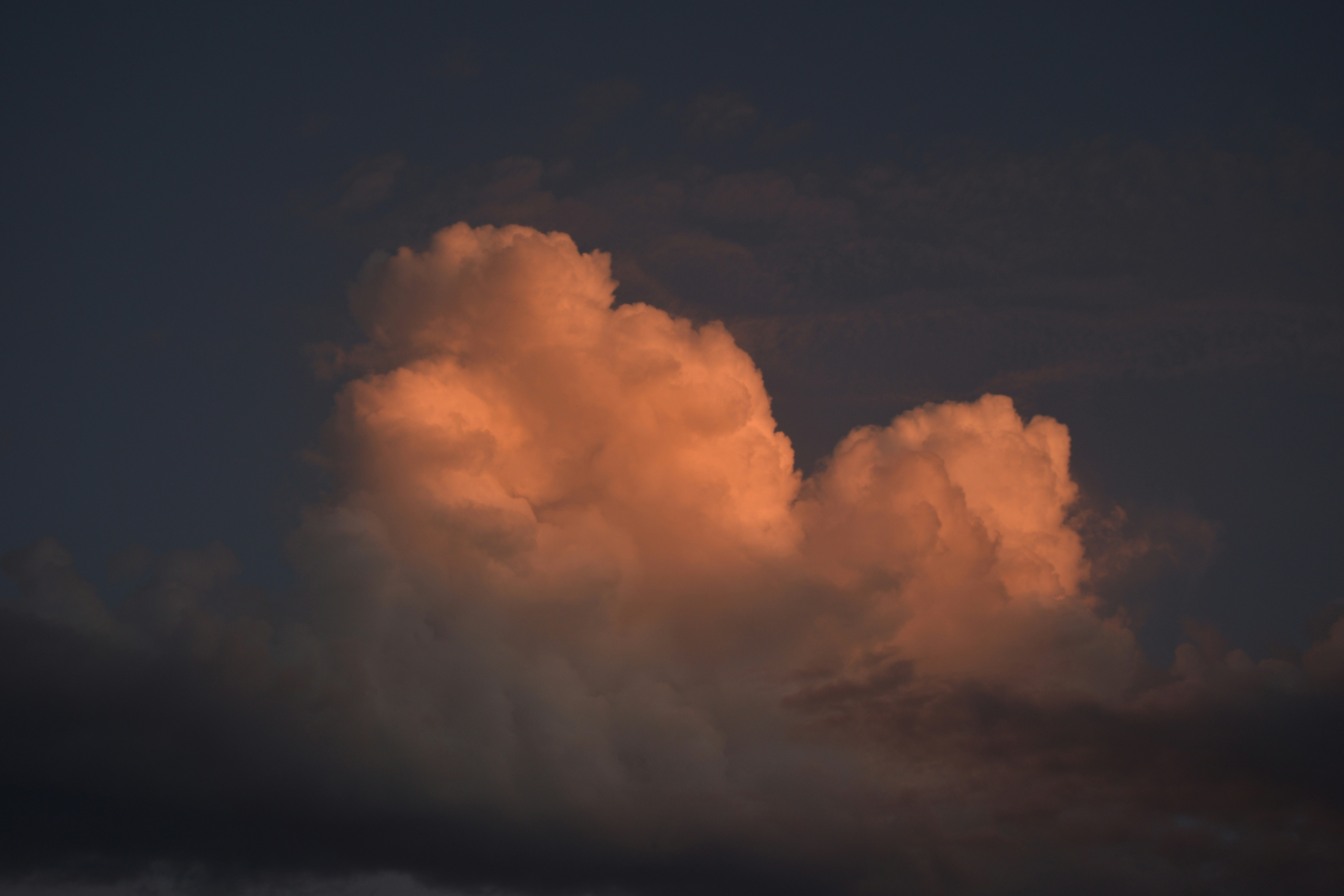 A large cloud is in the sky at night