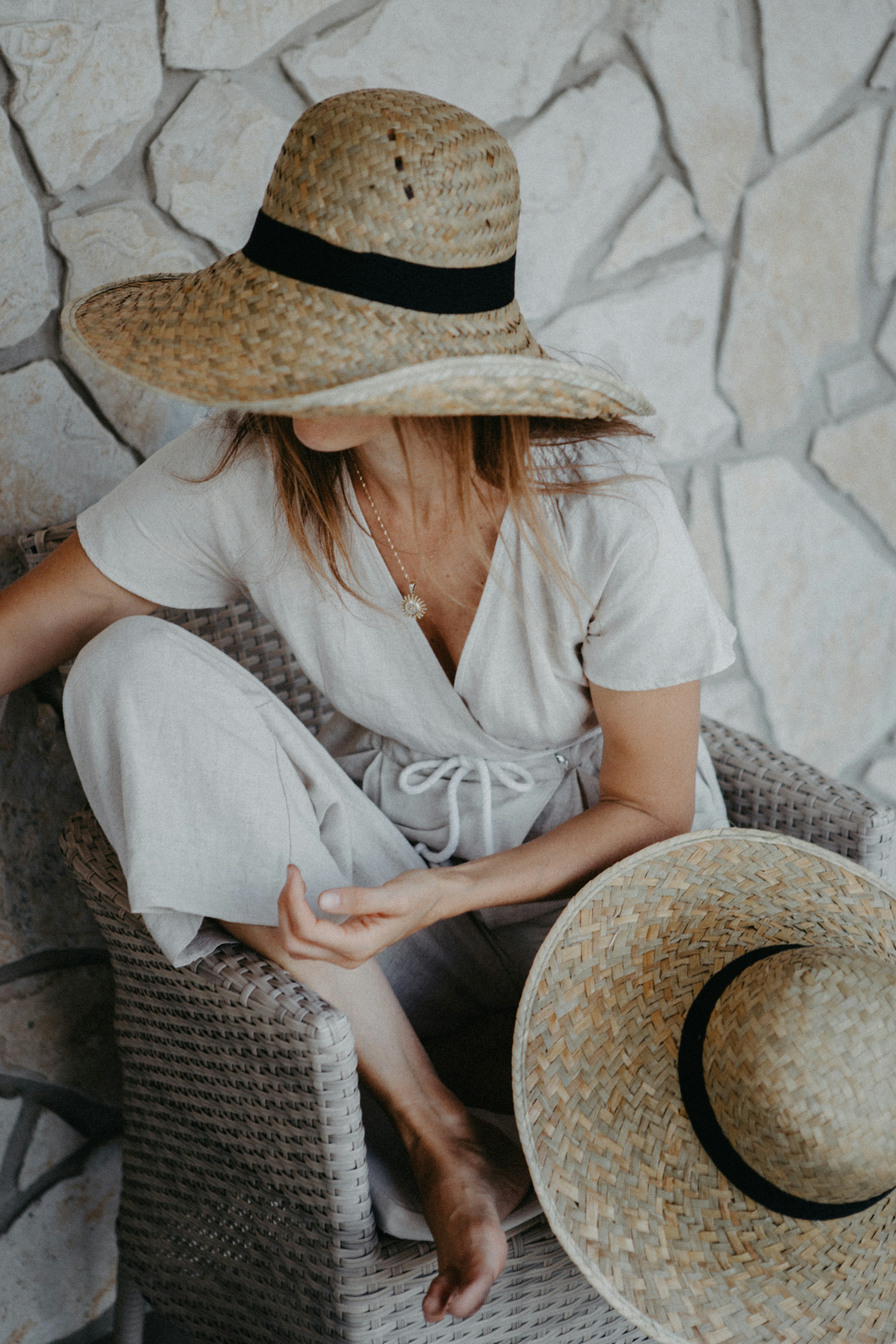 A woman sitting in a chair wearing a hat