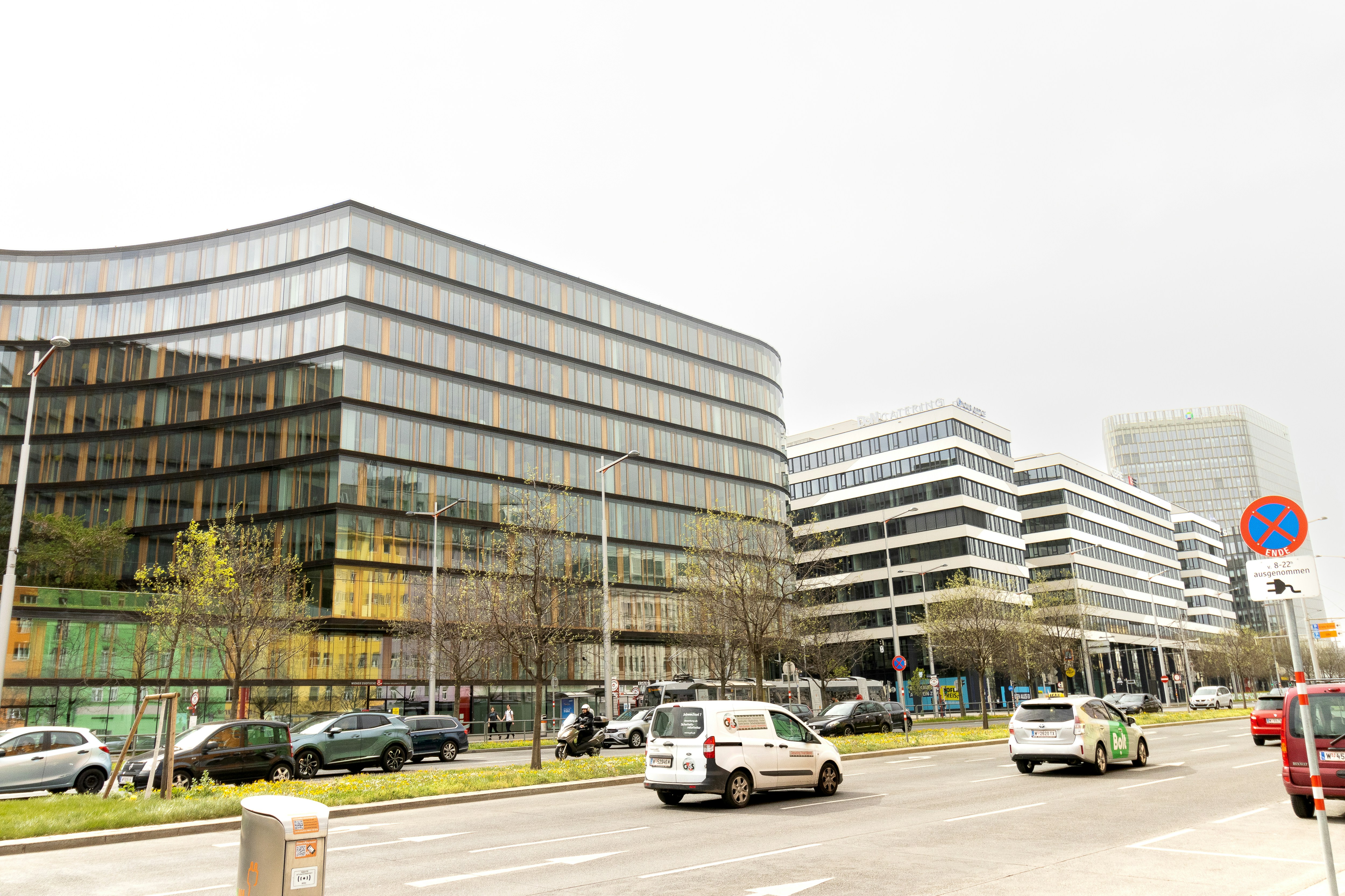 A city street filled with lots of traffic next to tall buildings