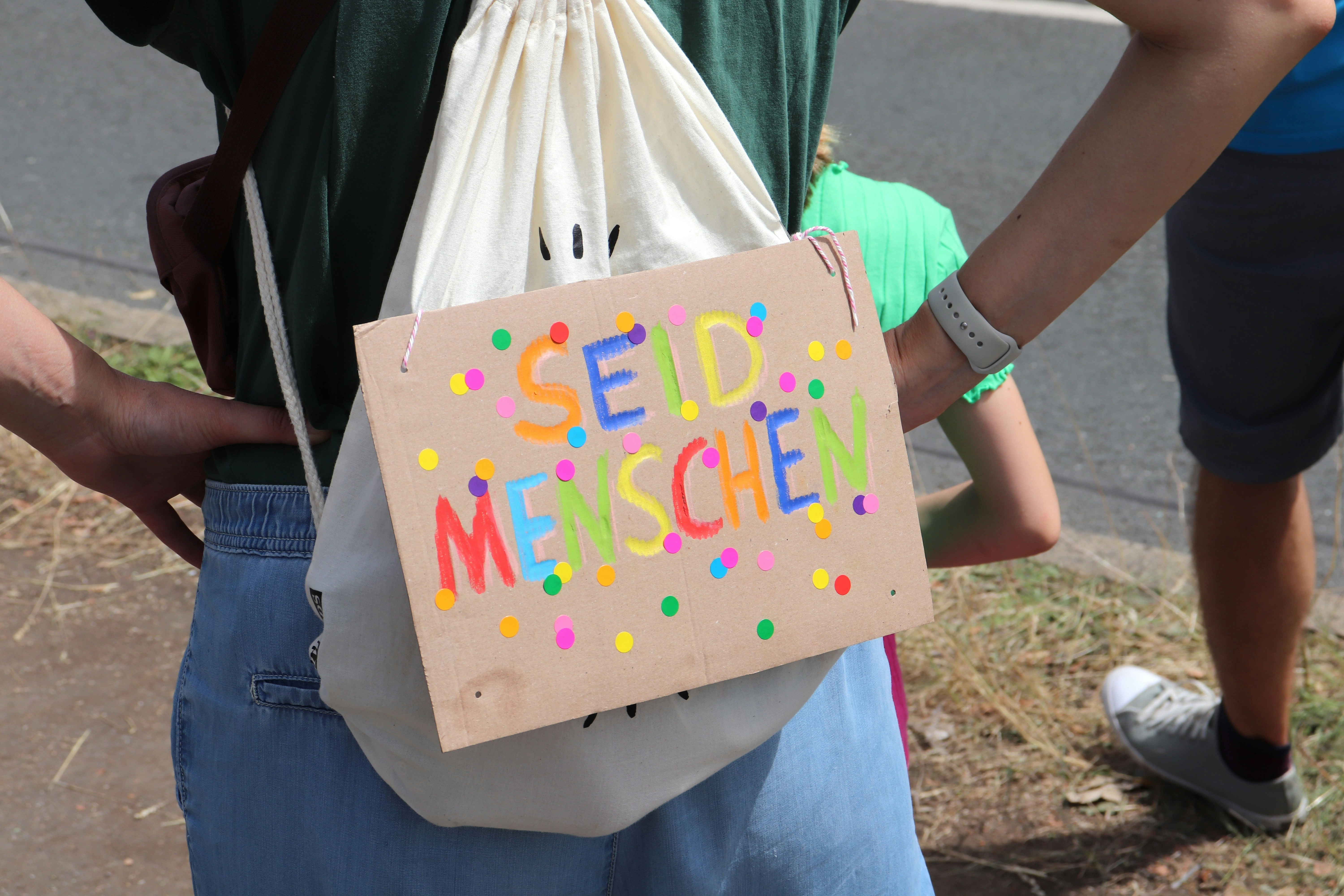 Ein Mann hält eine Tasche mit einer Botschaft darauf