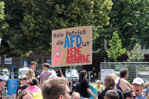 A group of people standing around each other holding signs