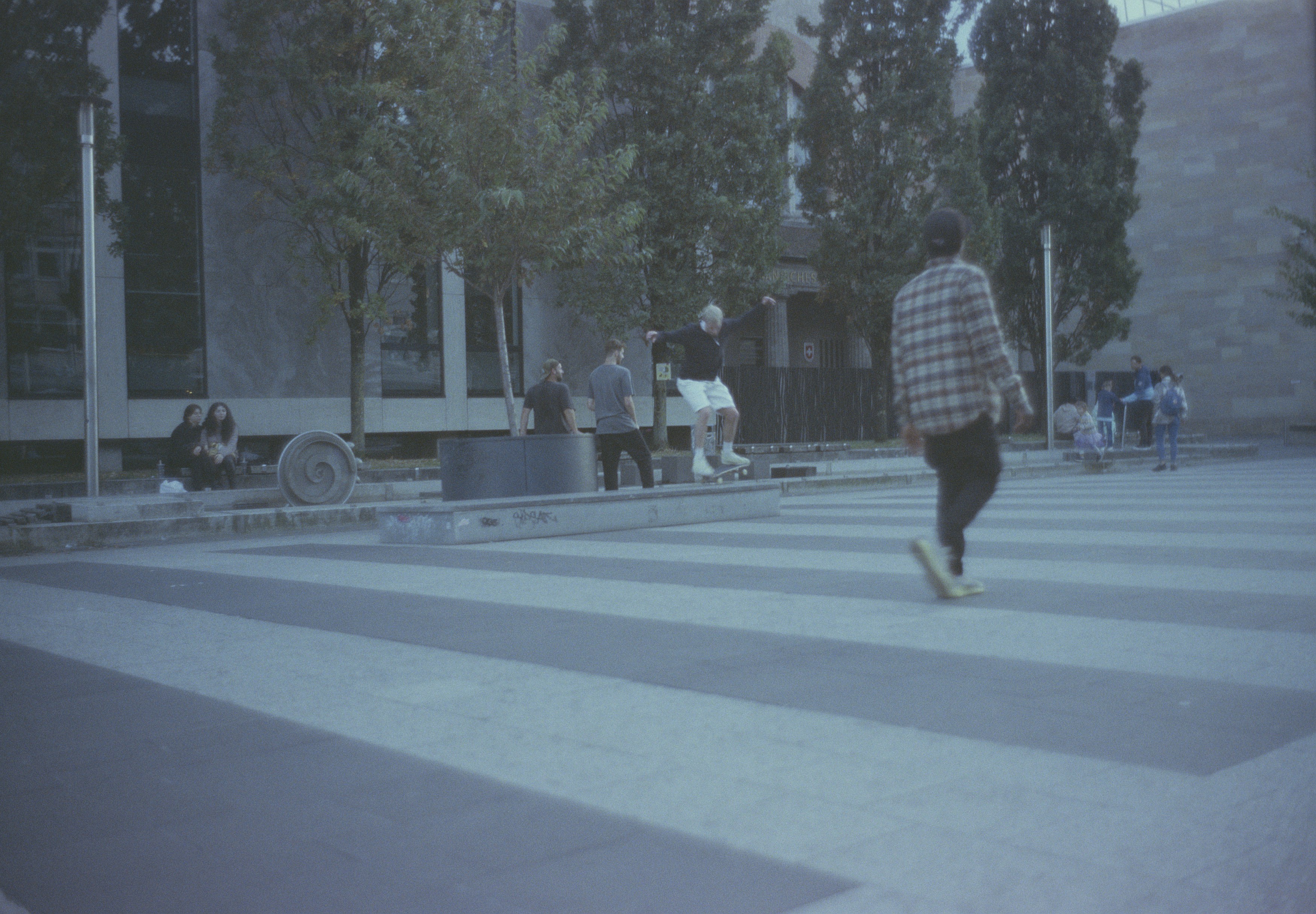Ein Mann fährt mit einem Skateboard über einen Zebrastreifen