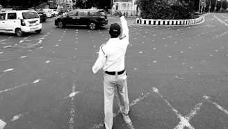 A man is standing in the middle of a parking lot