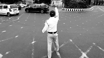 A man is standing in the middle of a parking lot