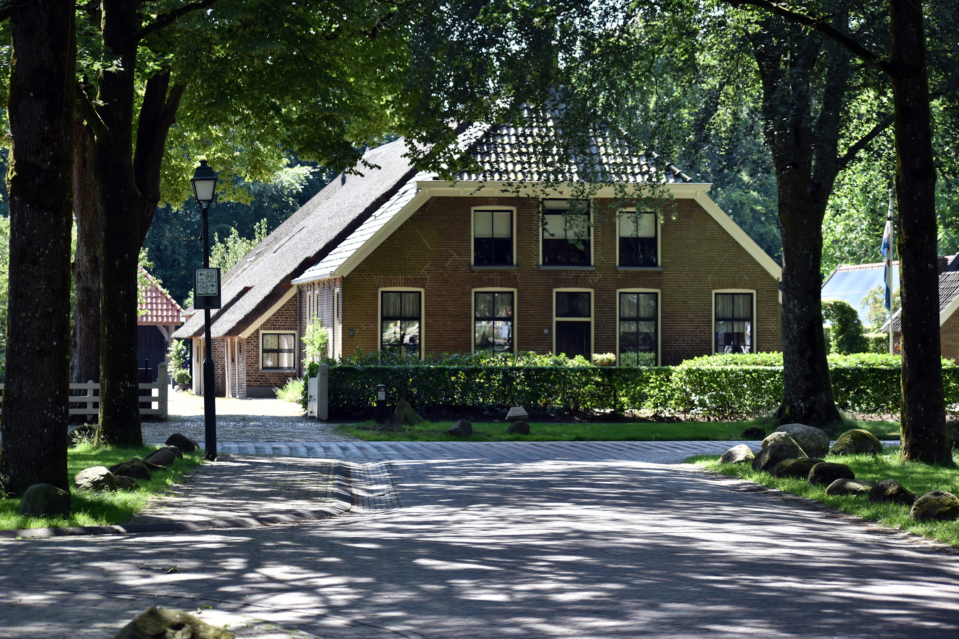 A house in the middle of a road surrounded by trees