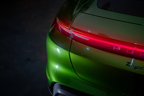 A close up of the tail lights of a green sports car