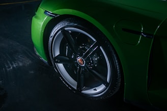 A green sports car parked in a garage