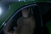 The interior of a green sports car with its lights on